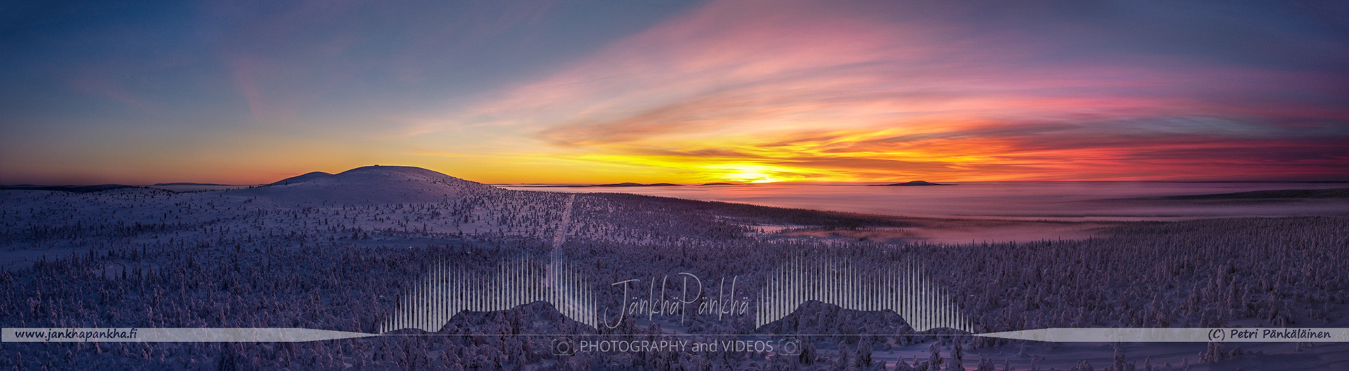 Vibrant orange and yellow hues painting the sky during a polar night in Lapland's Pallas-Yllästunturi National Park. Silhuette of the Sammaltunturi in the horizon.