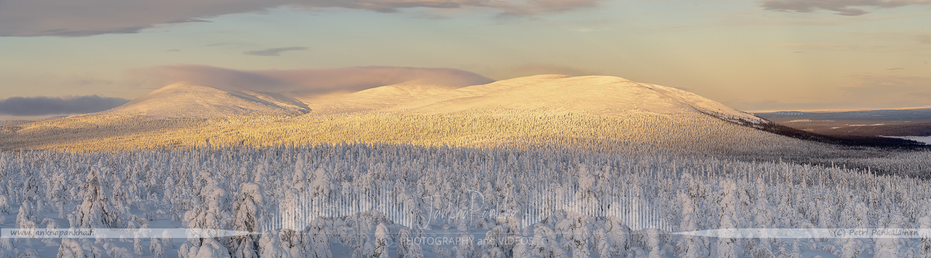 Orange and yellow sunset casting a warm glow over the snowy landscapes of Pallas-Yllästunturi National Park.