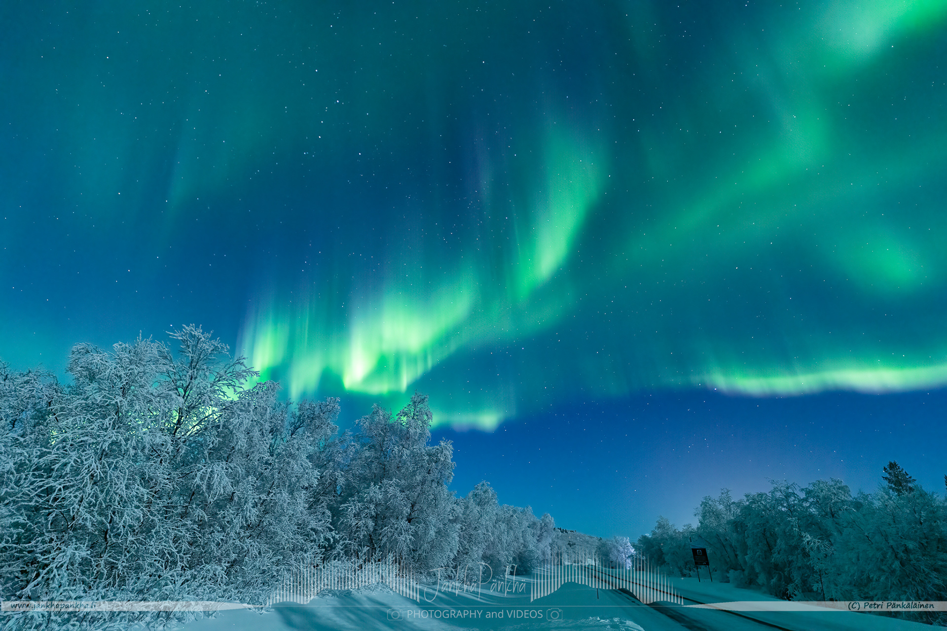 Full sky northern lights over the E4 / E75 road towards Utsjoki in Finland. The full moon eats up the intensity of the northern lights.