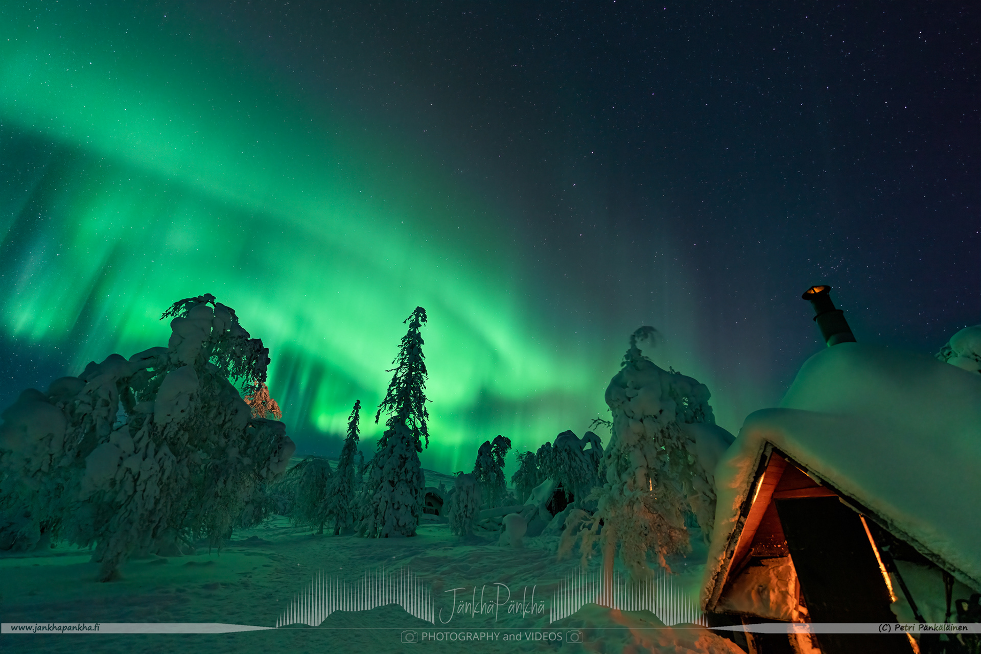 Northern lights over the snowy fell of Pallastunturi and Lappish hut in Muonio, Finland. 