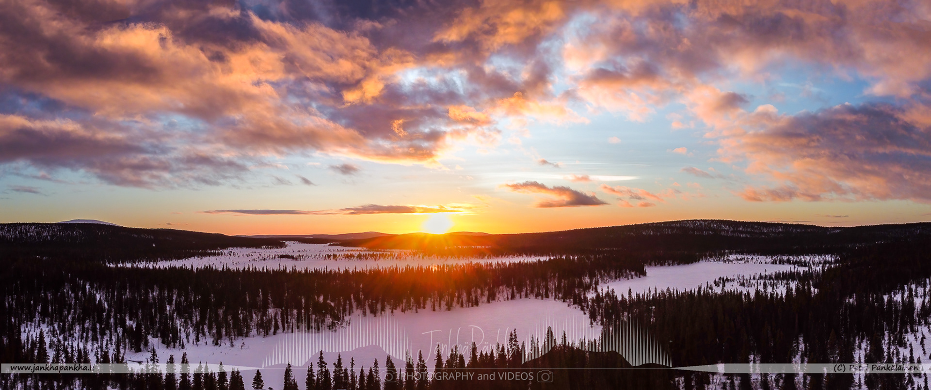 Vibrant orange and yellow hues painting the sky during a polar night in Lapland's Pallas-Yllästunturi National Park.