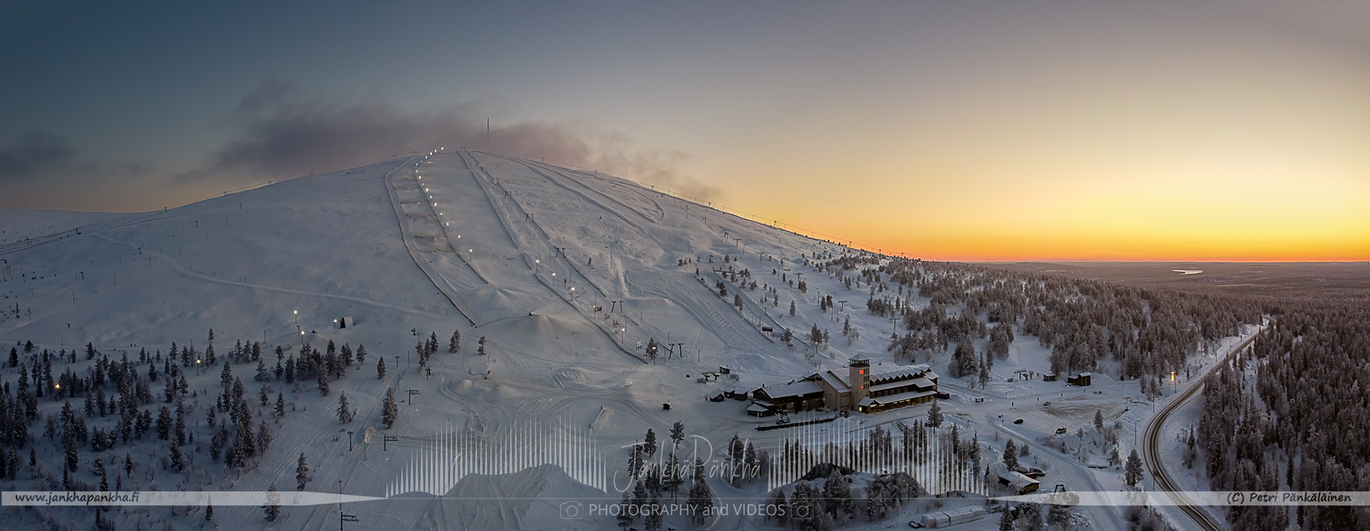 Orange and yellow sunset casting a warm glow over the snowy landscapes of Yllästunturi and Ylläs Ski Resort, Äkäslompolo.