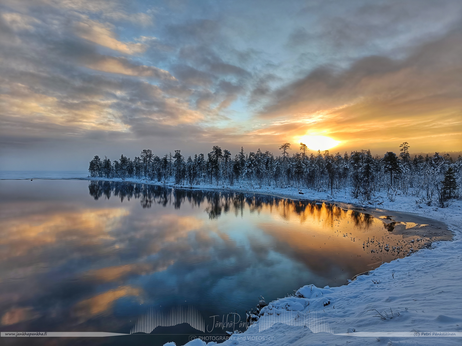 Autumn sunset in Kutuniva, Muonio with a beautiful reflections from the lake. First snow has already covered the coastline and trees.