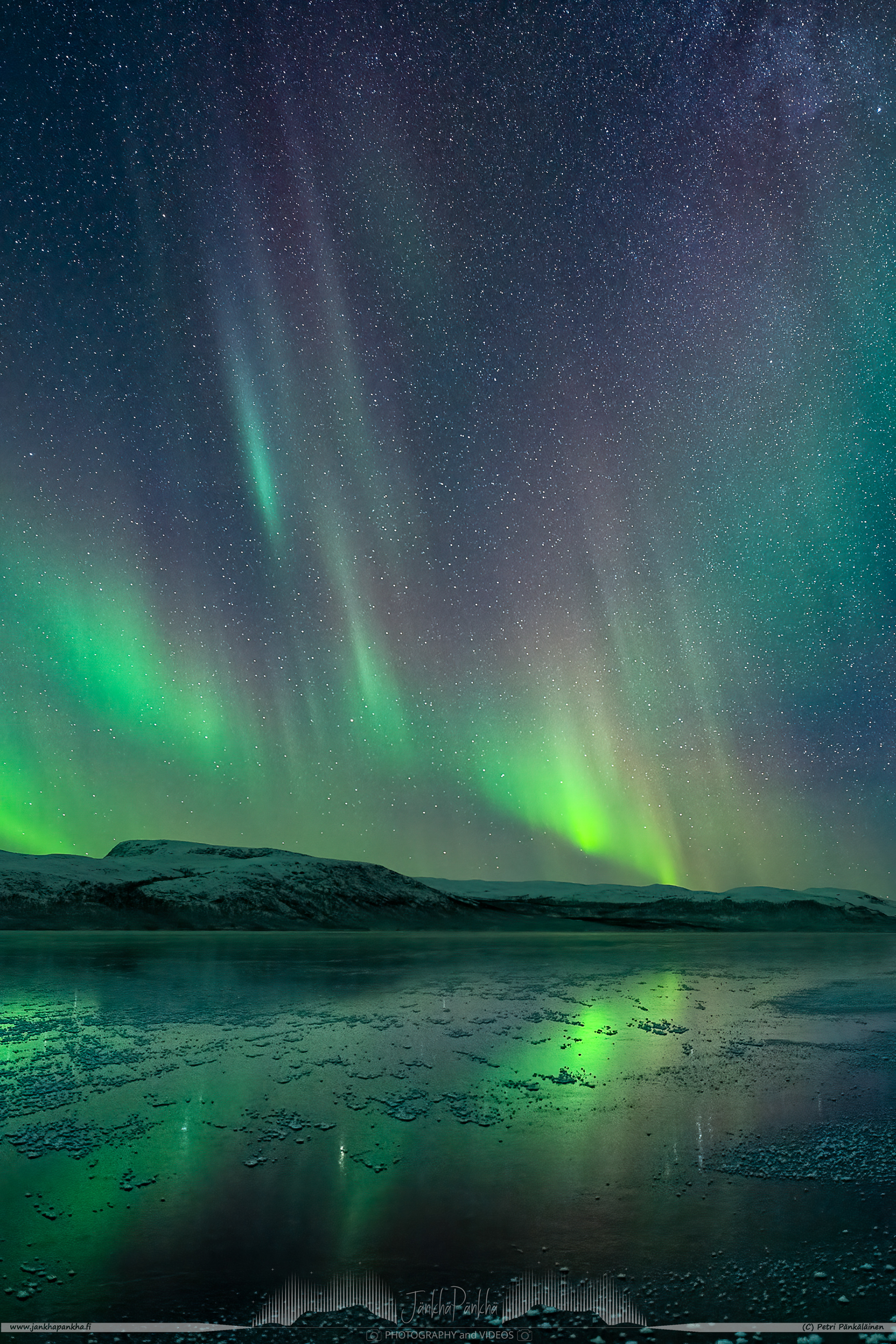 Visit Enontekiö to witness Intense and colorful northern lights over the mirror-like iced lake Ala-Kilpisjärvi.
