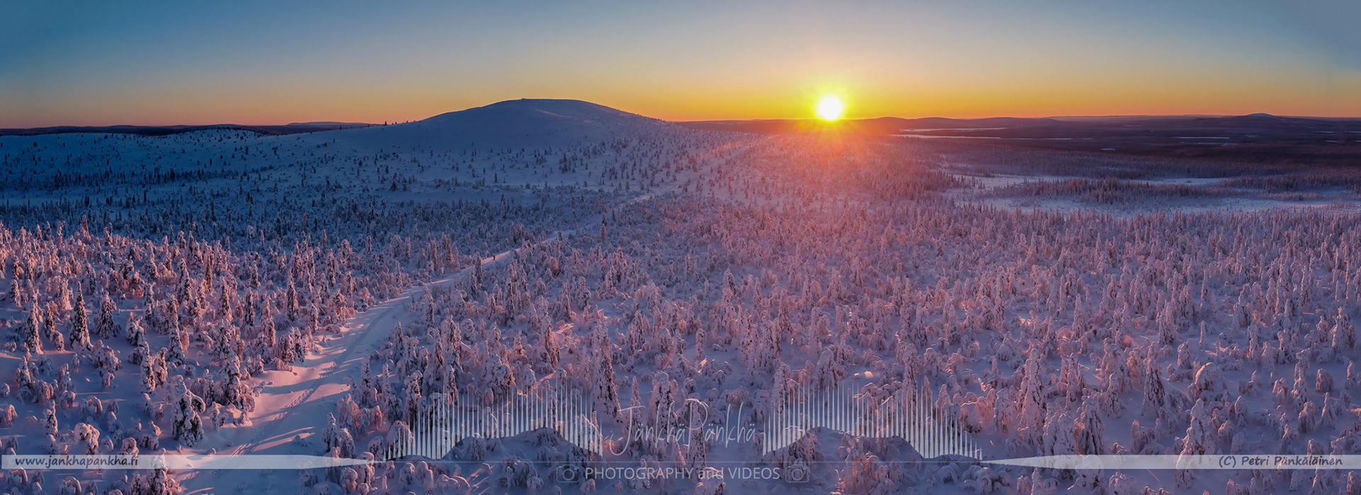 Vibrant orange and yellow hues painting the sky during a polar night in Lapland's Pallas-Yllästunturi National Park. Silhuette of the Sammaltunturi in the horizon.