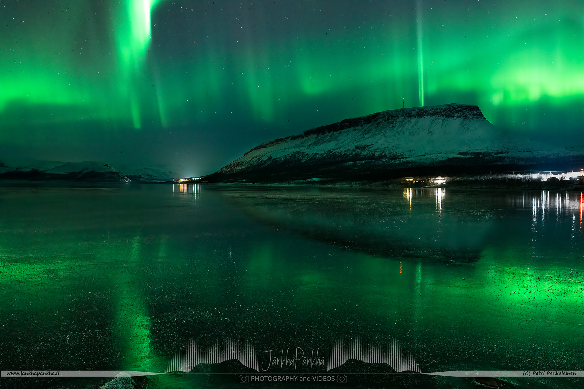 Saanatunturi, fell Saana, in Kilpisjärvi surrounded by the fast moving northern lights and mirror-like ice cover on the lake Kilpisjärvi.