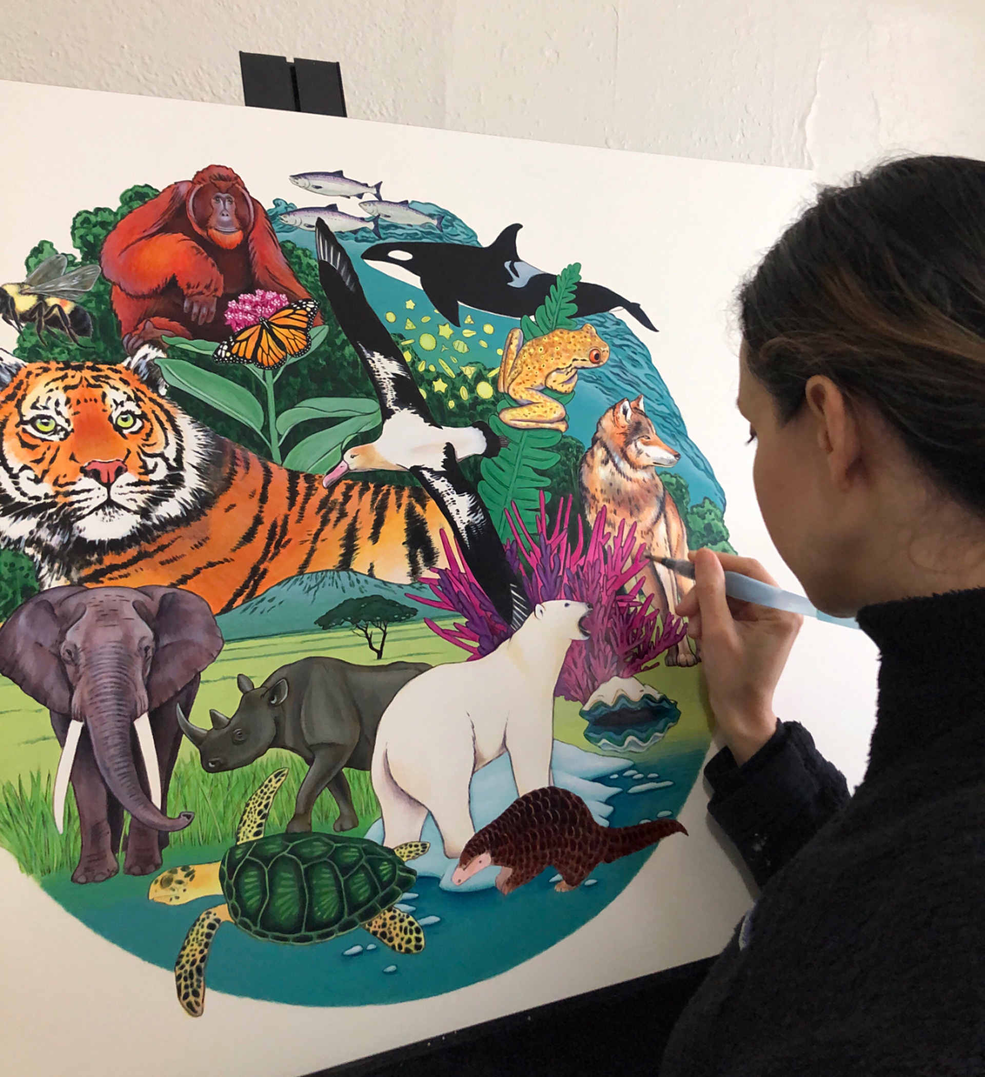 Artist Fiorella Ikeue working on a painting of Earth's endangered species and habitats