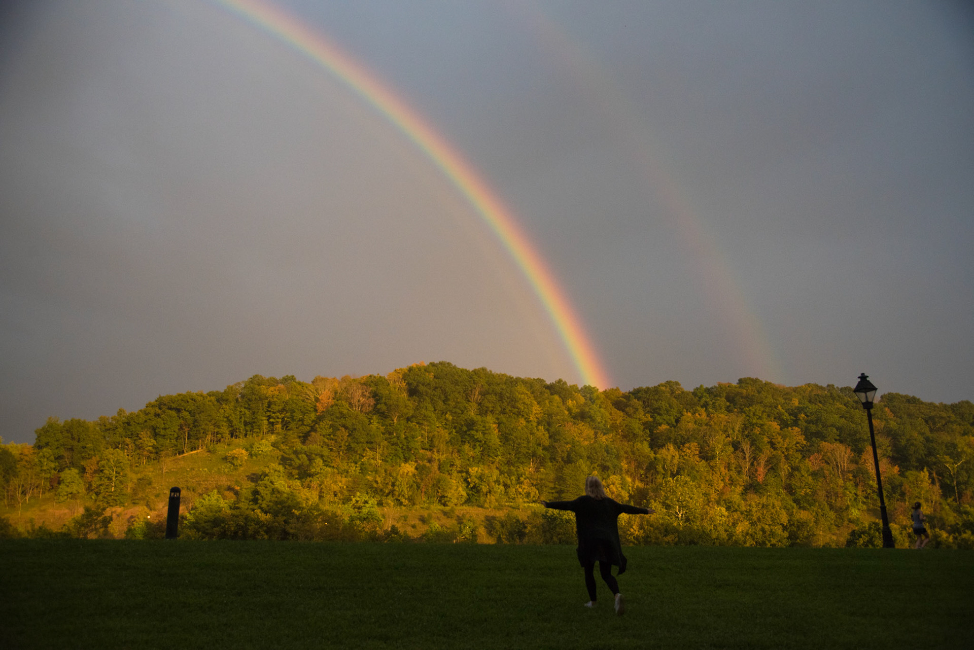 Cameron Cheevers runs towards the double rainbow on South Green of Ohio University on September, 14, 2017.