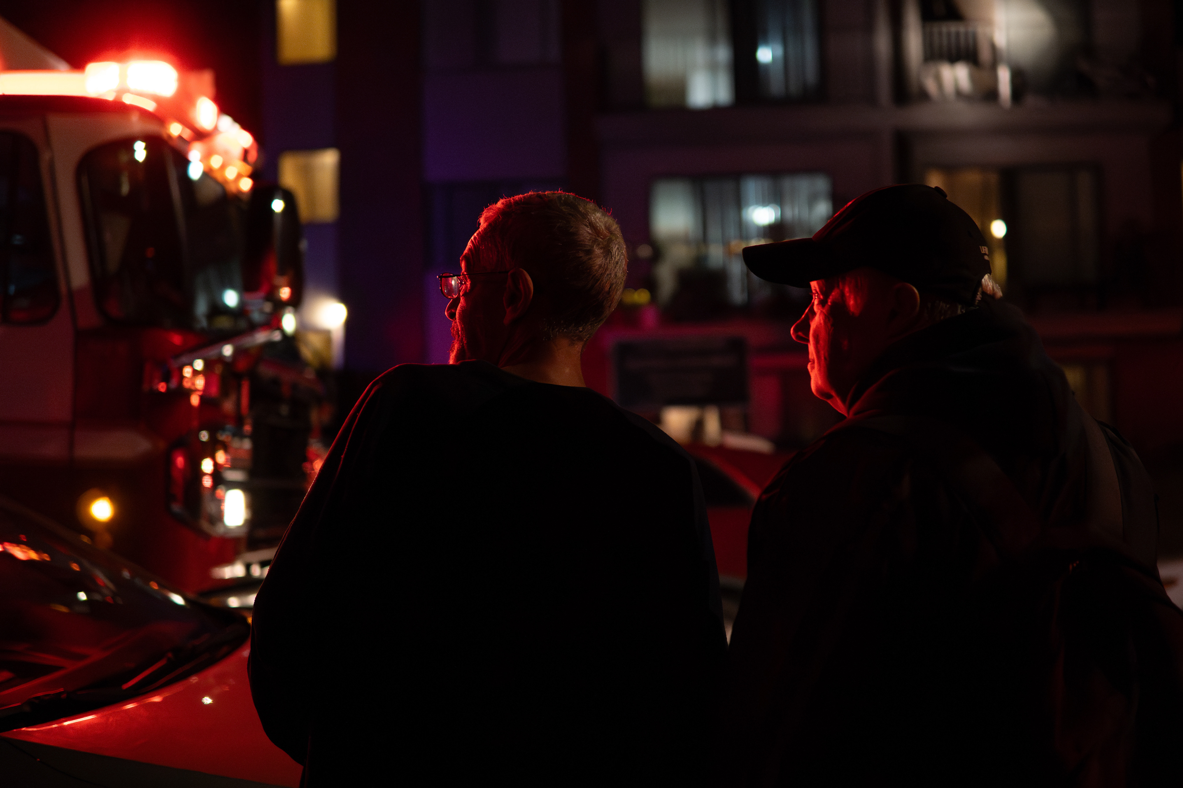 Myron Hassan, Left, and a neighbour watch firetrucks responding to an apartment fire at Bankviews 16a St SW in Calgary on Tuesday, Oct. 1, 2024