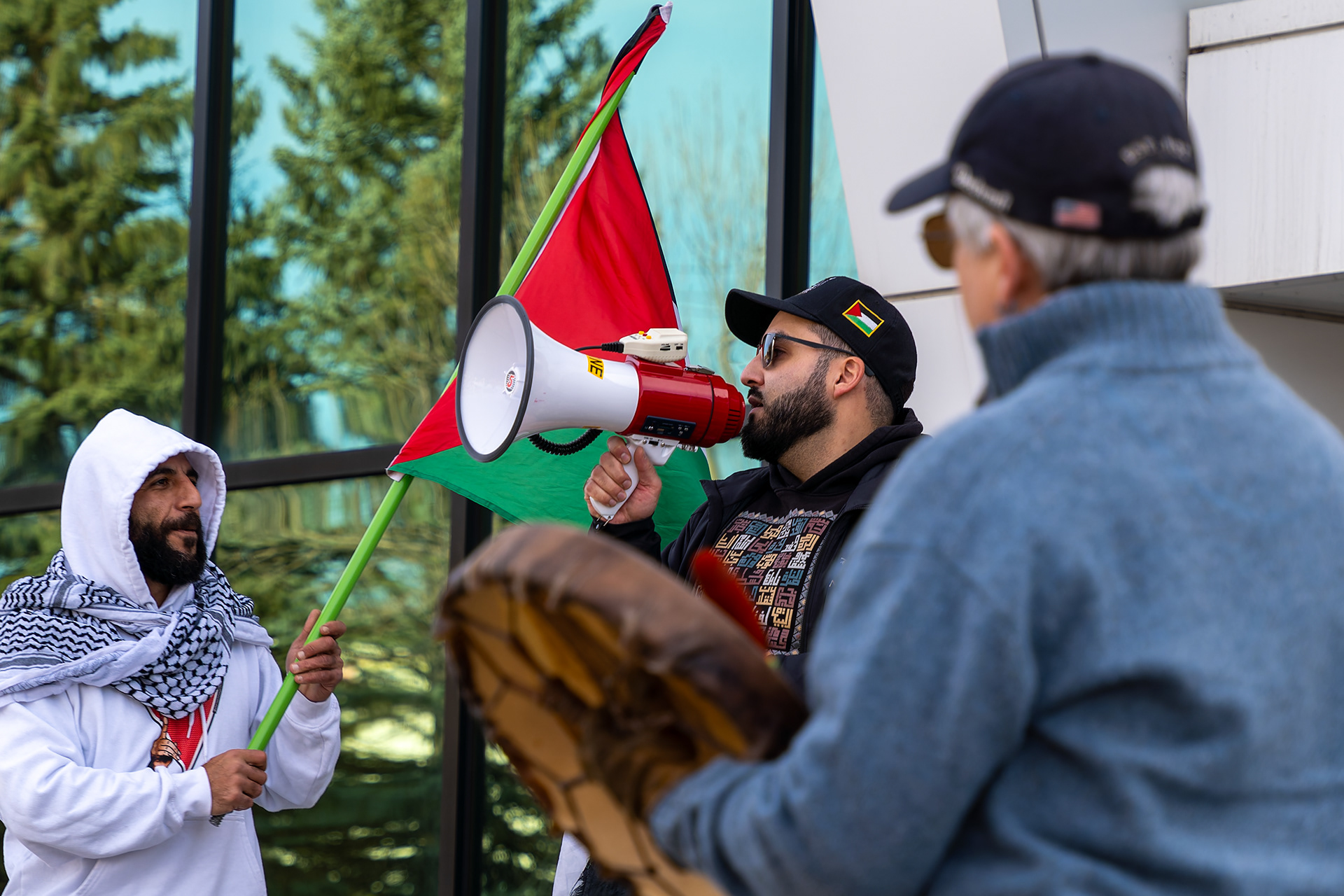 Protestors gather outside of the Raytheon technologies office in Calgary on Saturday, Nov. 16, 2024.