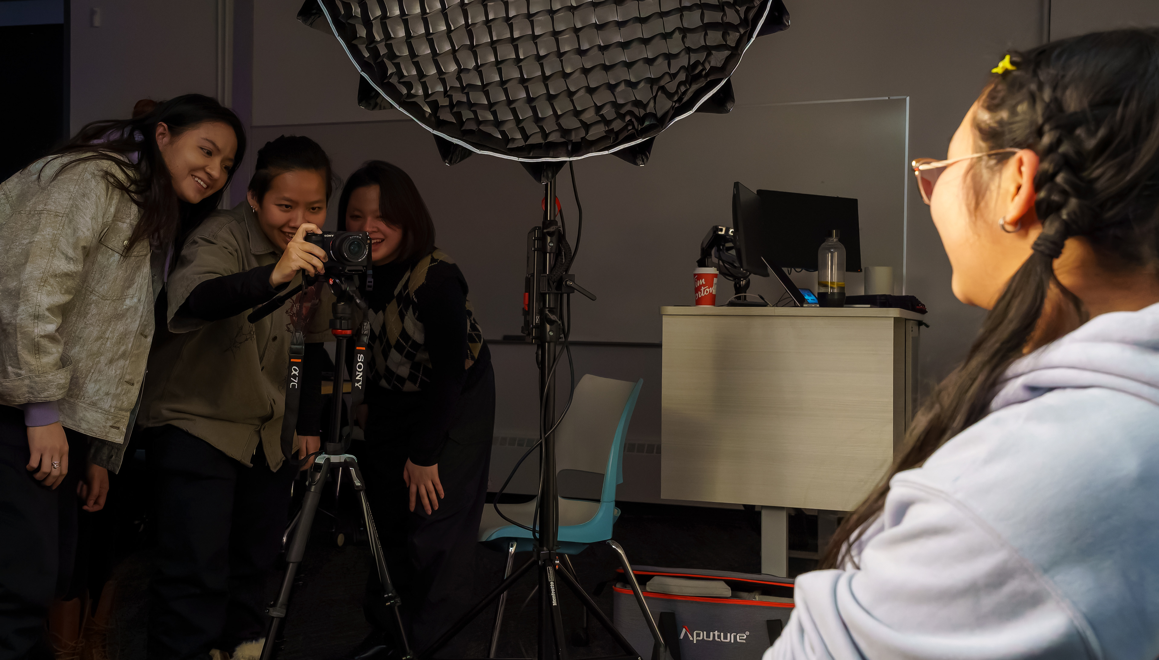 Jessica Luc has her picture taken during a lighting demonstration by first year interactive design students Phuong Tran, left, Huong Le, middle, Minh Khoa, right, in the Senator Burns Building at SAIT in Calgary on Wednesday, Feb. 12, 2025. 