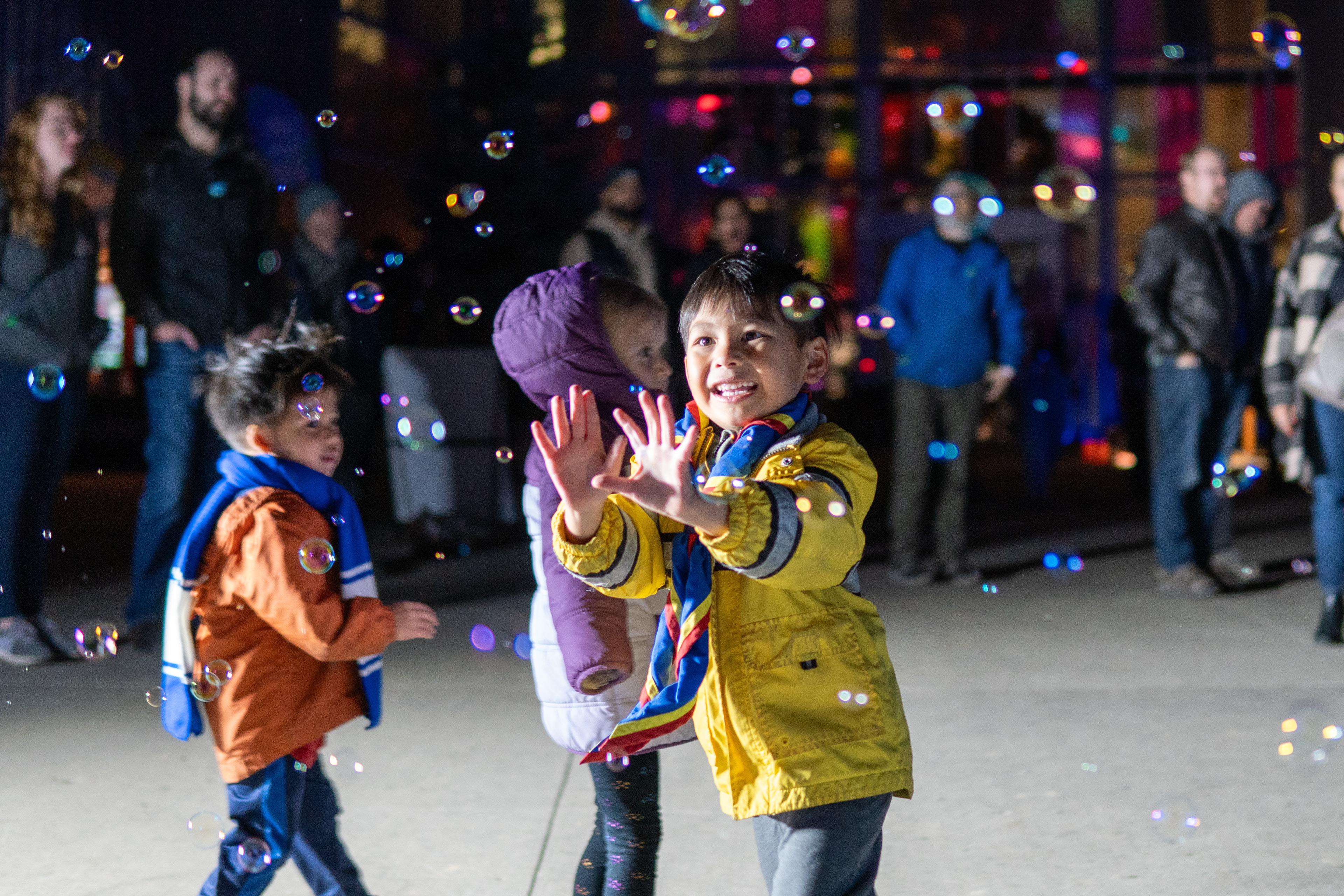 Children play in with the bubbles from a science demonstration at Beakerhead at the TELUS Spark Science Centre in Calgary on Friday, Sept. 20, 2024