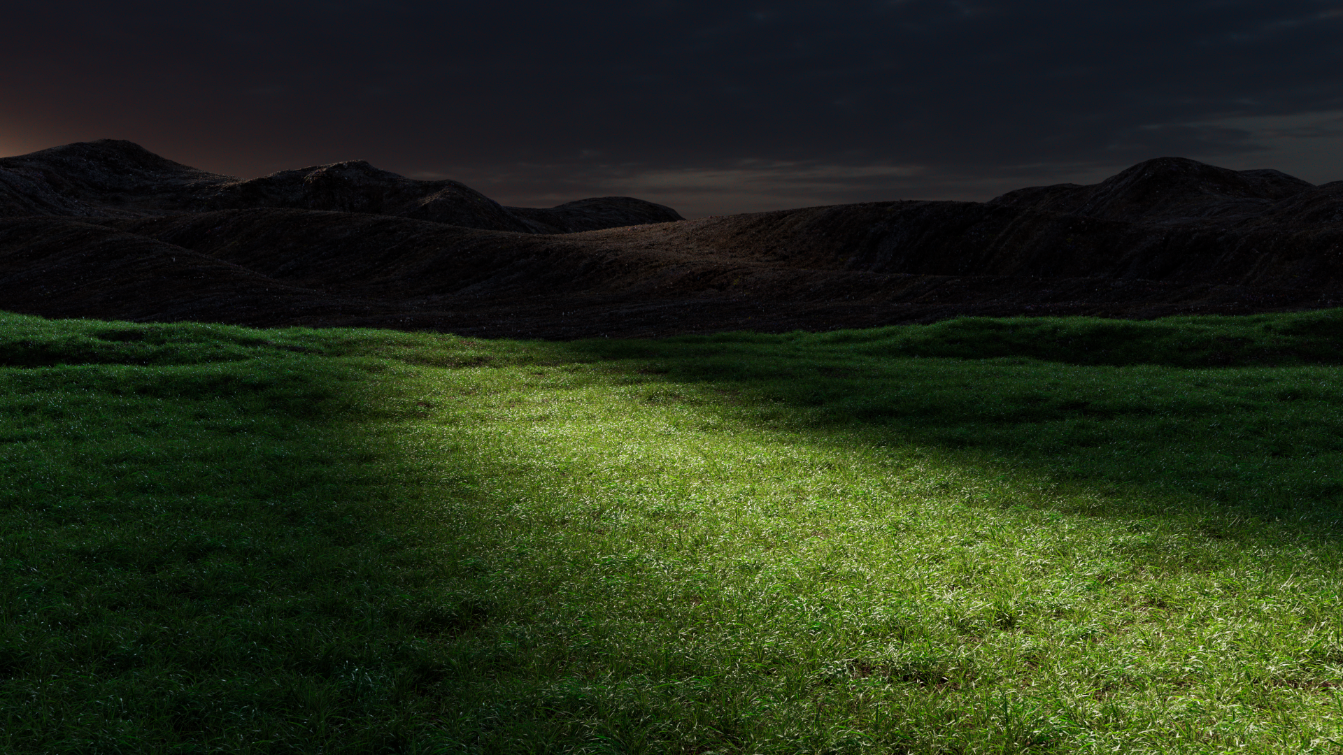 A dark, grassy field illuminated by a spotlight, showing the lush green lawn mower's design.