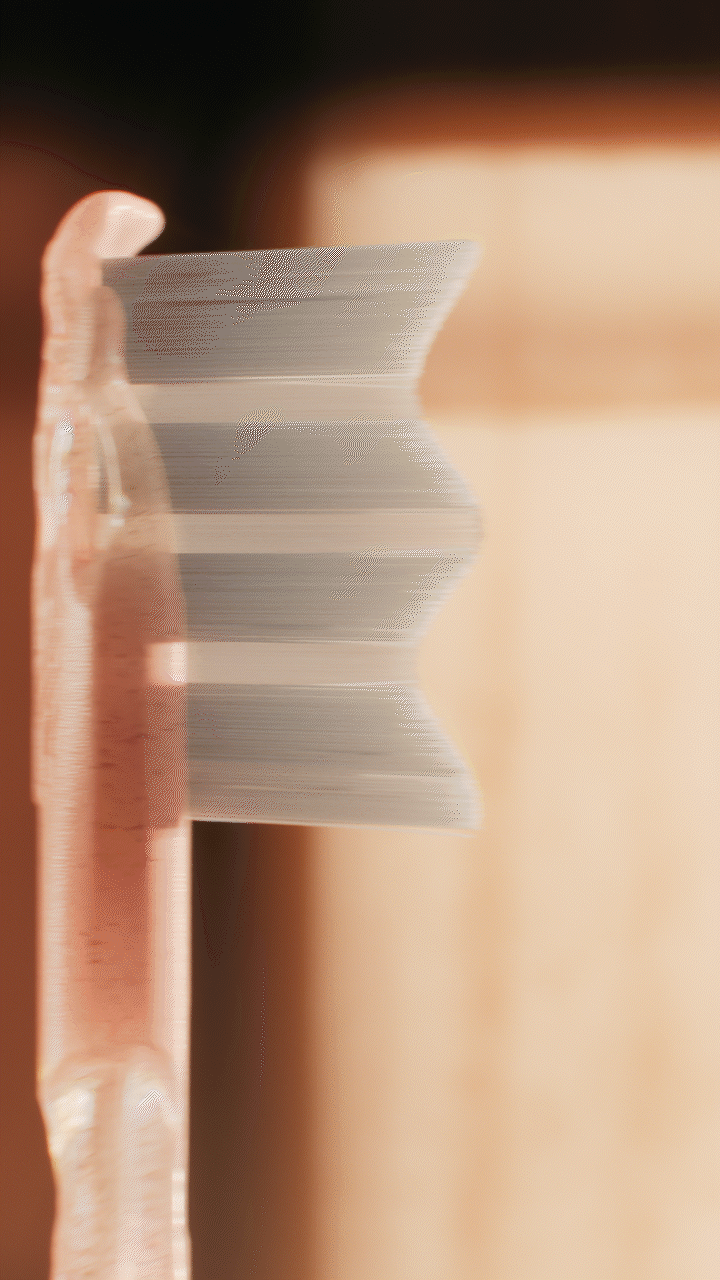 Animated sequence: A close-up of a pink toothbrush with white bristles against a blurred background.
