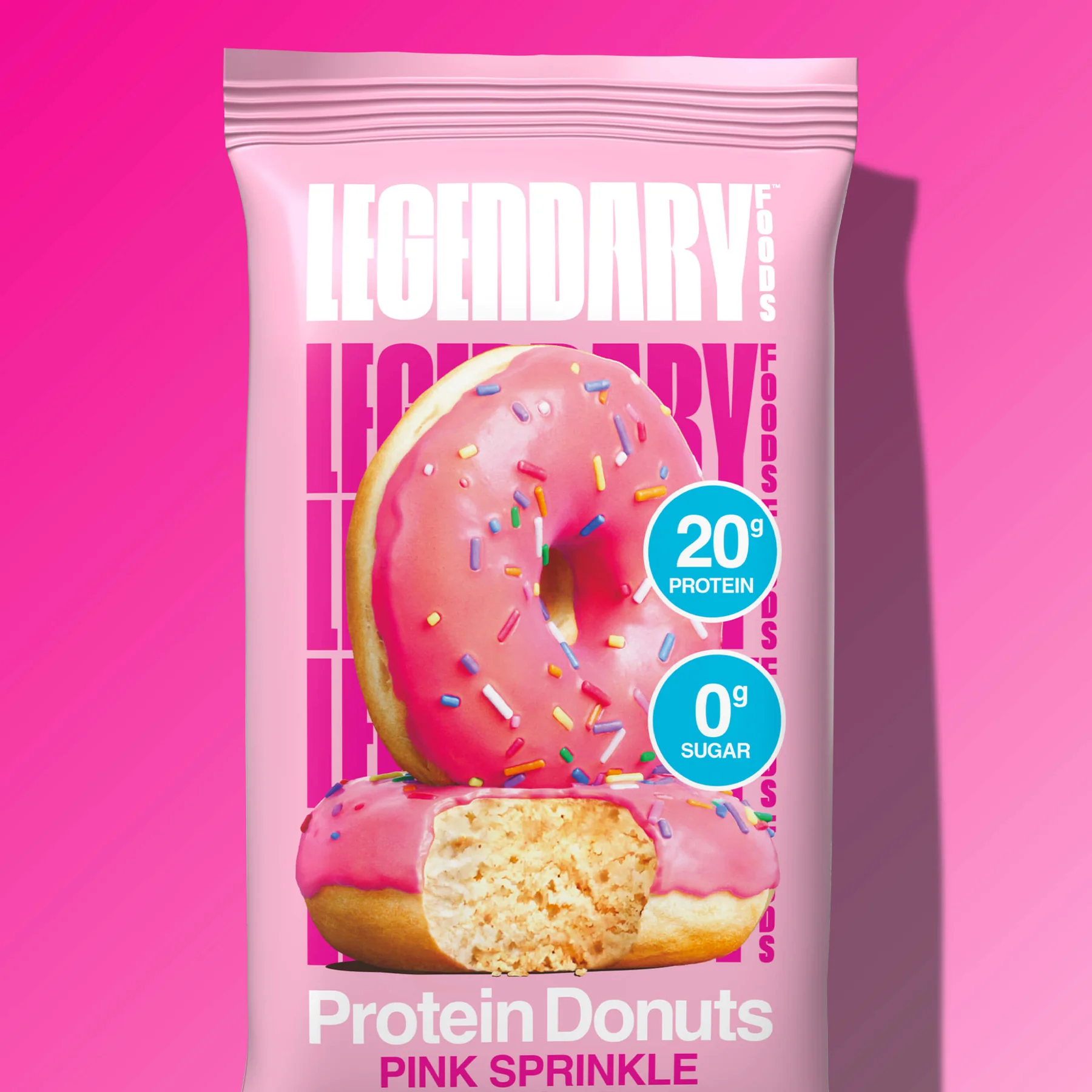 A pink protein donut bar with sprinkles, labeled "Legendary Foods Protein Donuts Pink Sprinkle," boasting 20 grams of protein and zero grams of sugar.