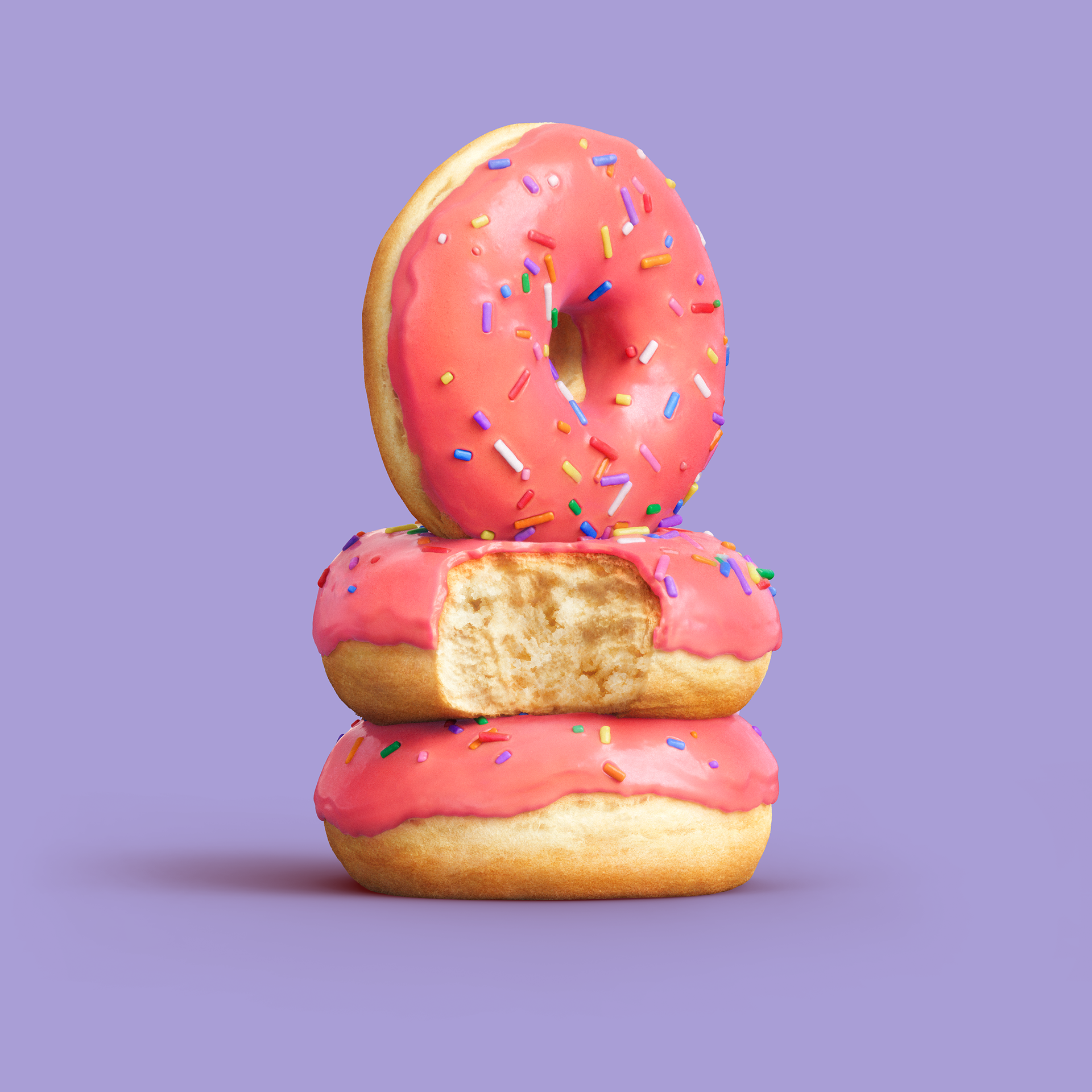 Three pink frosted donuts stacked on a purple background, with sprinkles scattered around.