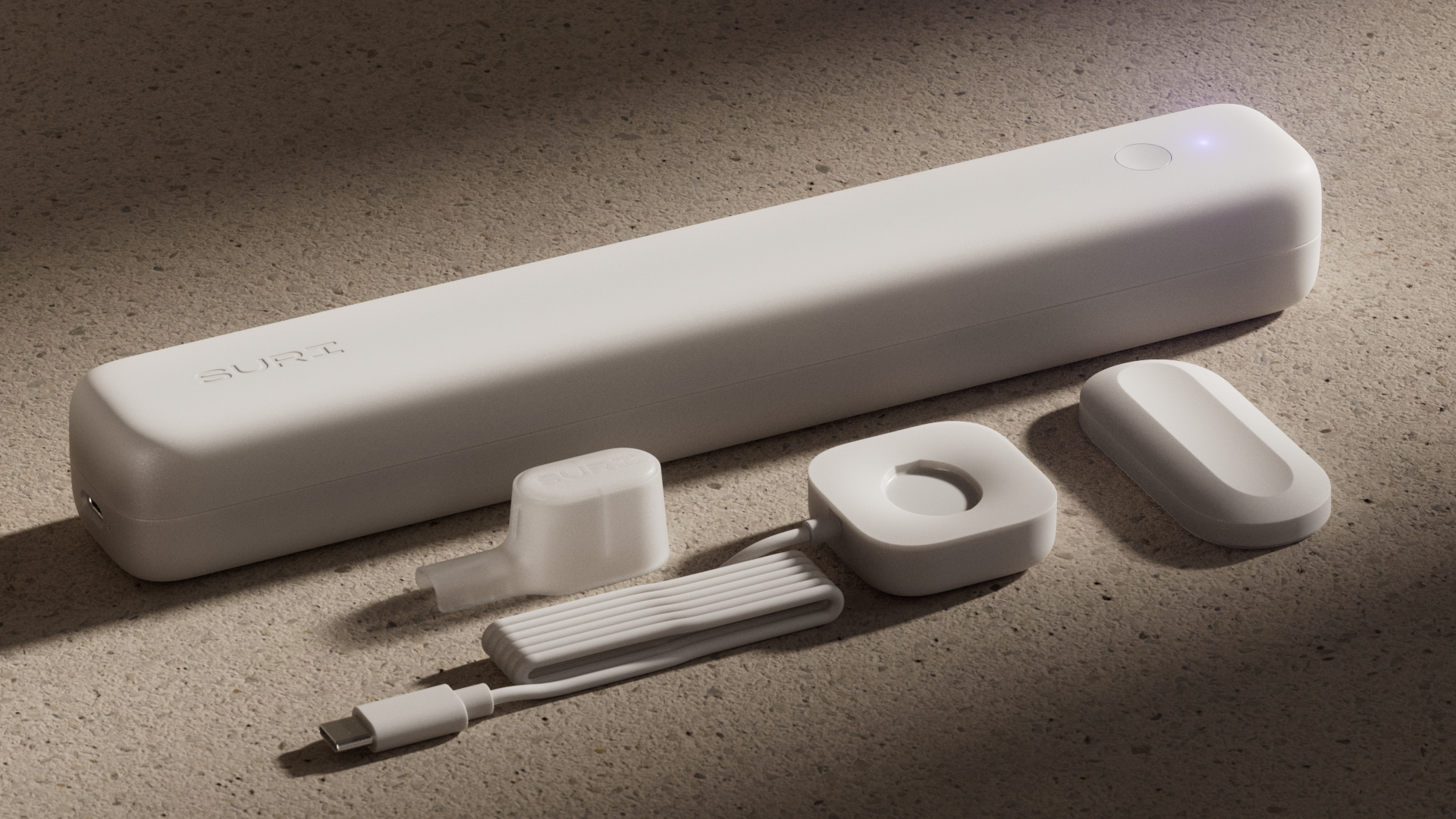 A white device with "SURI" branding, accompanied by a charging cable, case, and accessories on a textured surface.