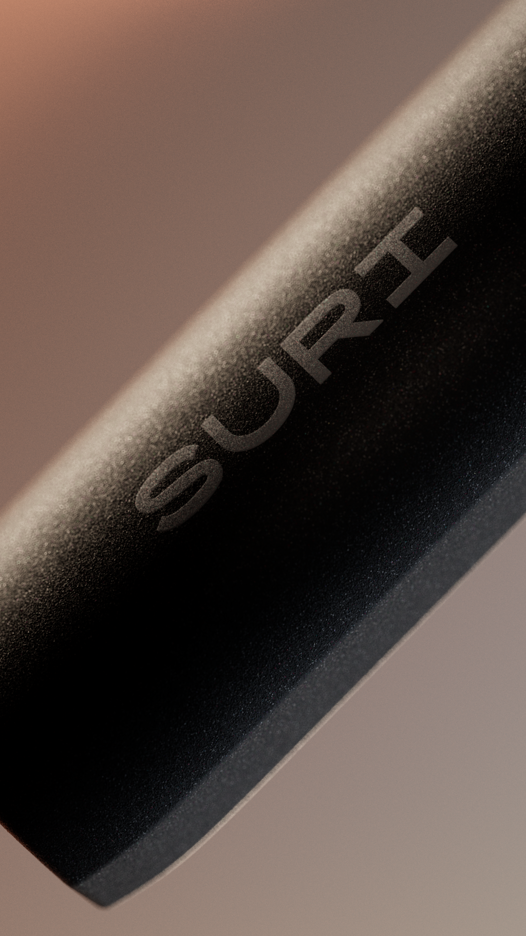 A close-up of a sleek, black device with the word "SURI" engraved on its surface.