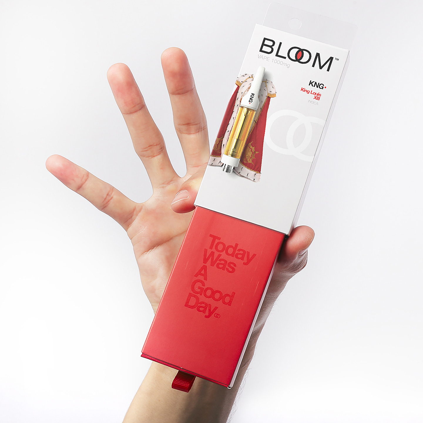 A hand holds a red BLOOM vape pen box with "Today Was A Good Day" written on it.