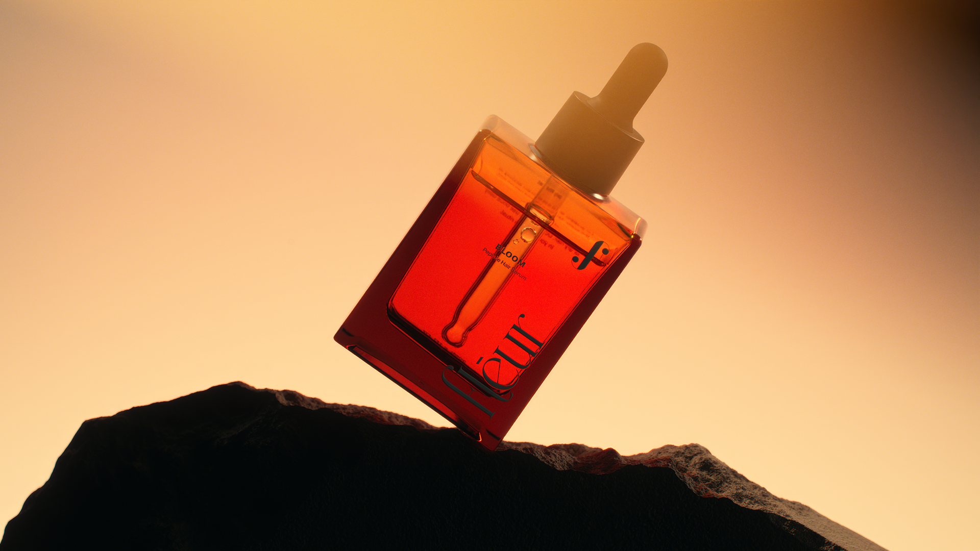 A dropper bottle filled with vibrant orange liquid, labeled "Fleur," balances precariously on a dark rock against a warm, gradient background.