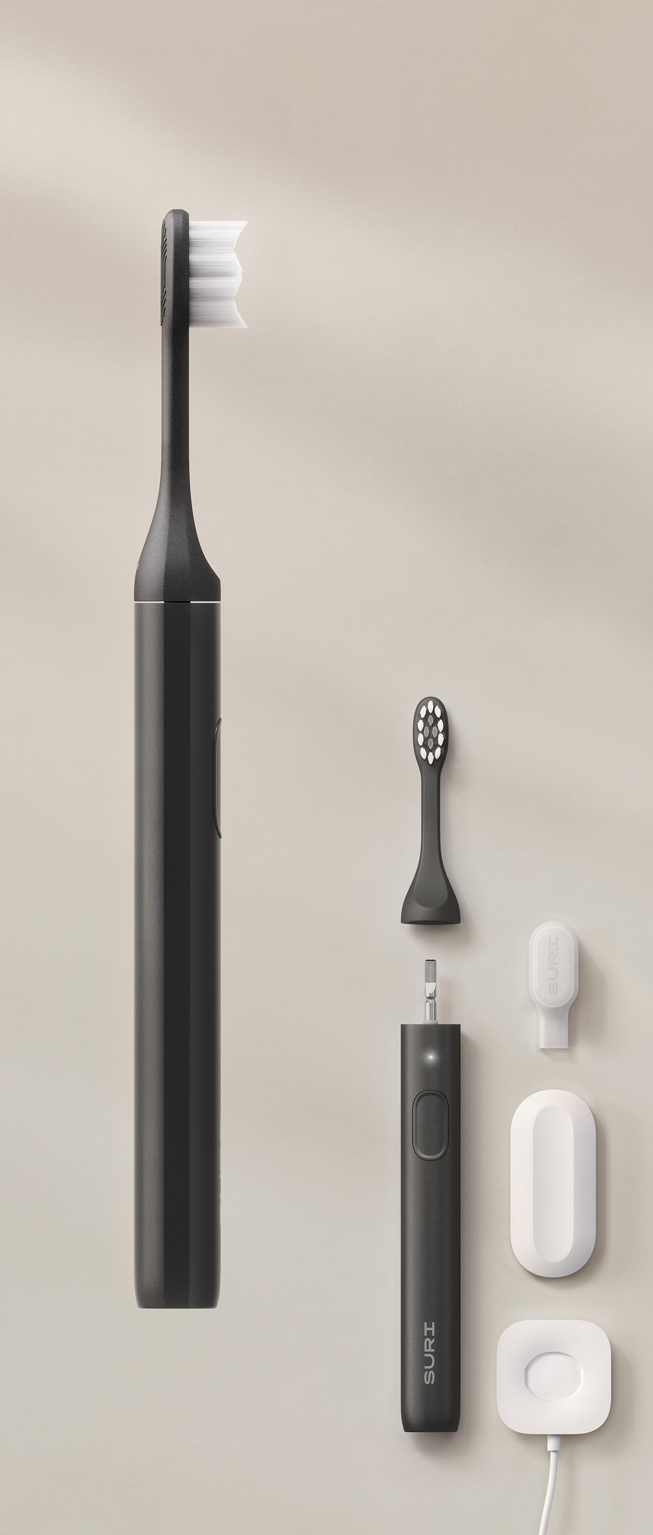 A black electric toothbrush with a white bristle head, accompanied by its charging base and travel case.