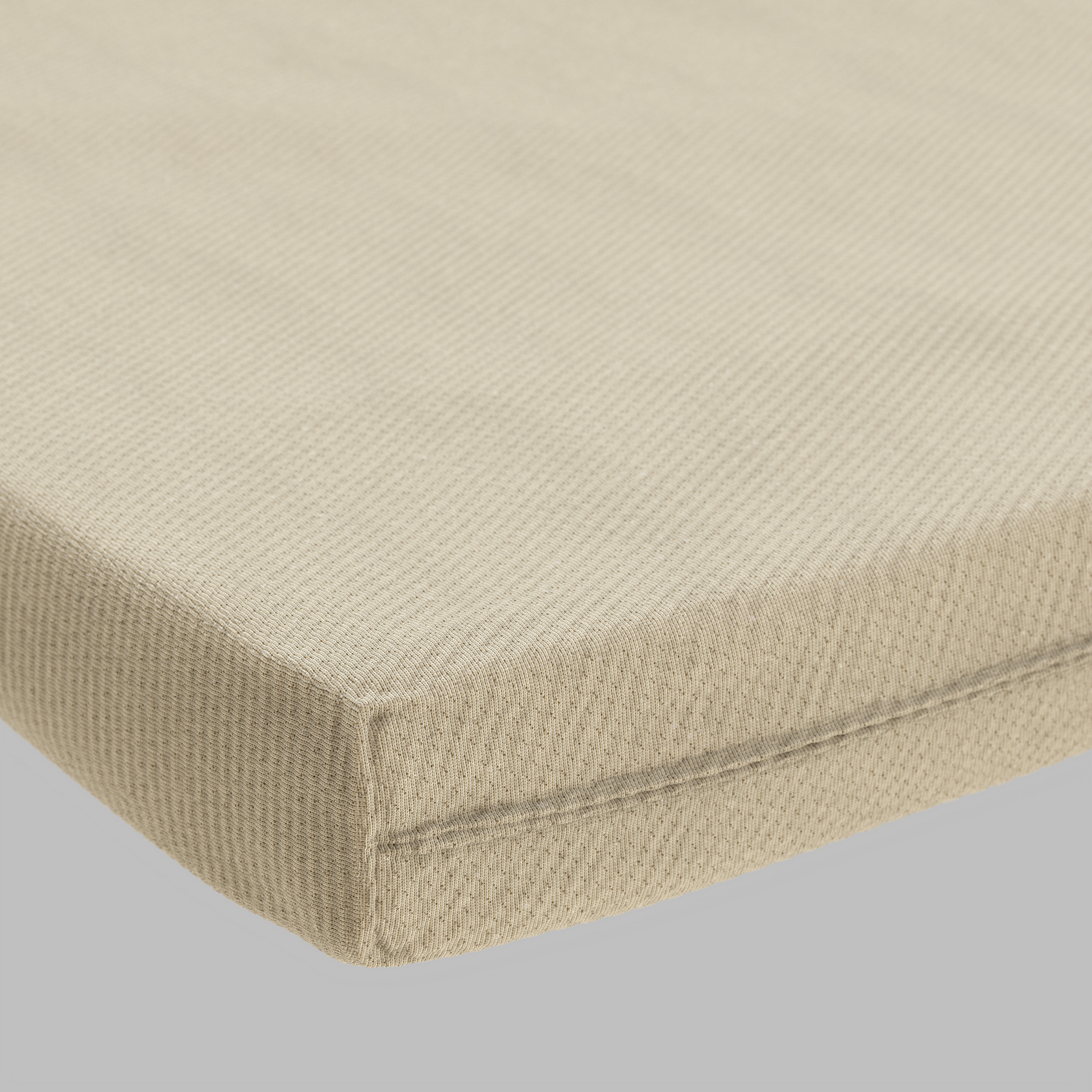 A close-up of a natural fiber mattress cover, showing its texture and color.