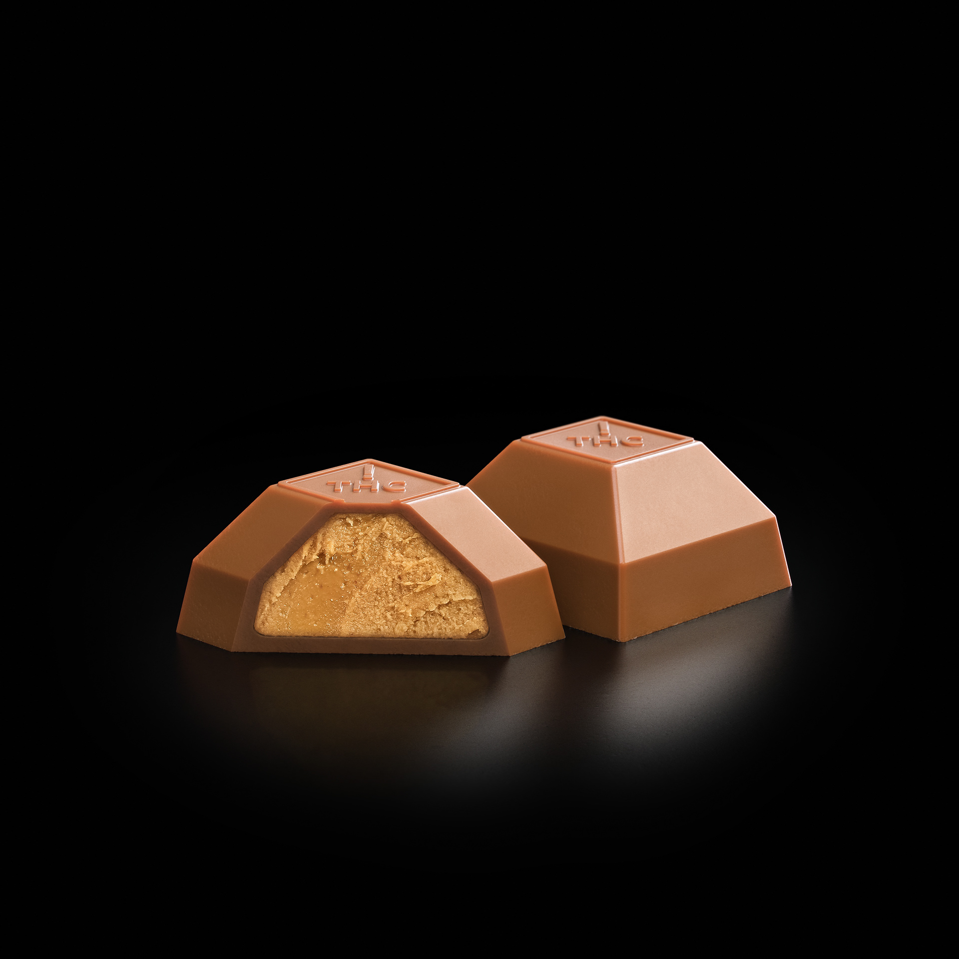 A premium chocolate bar with a golden center, cut open to reveal its creamy texture, set against a dark background.