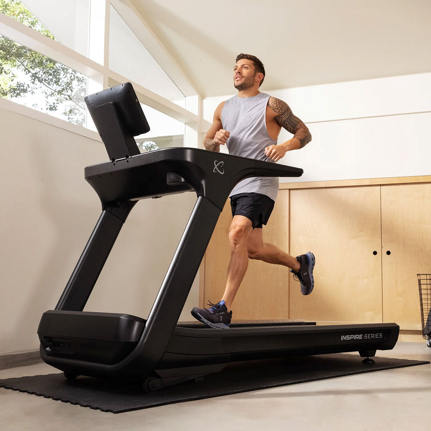 A person running on a black treadmill with the brand name "Centr" visible on the console.