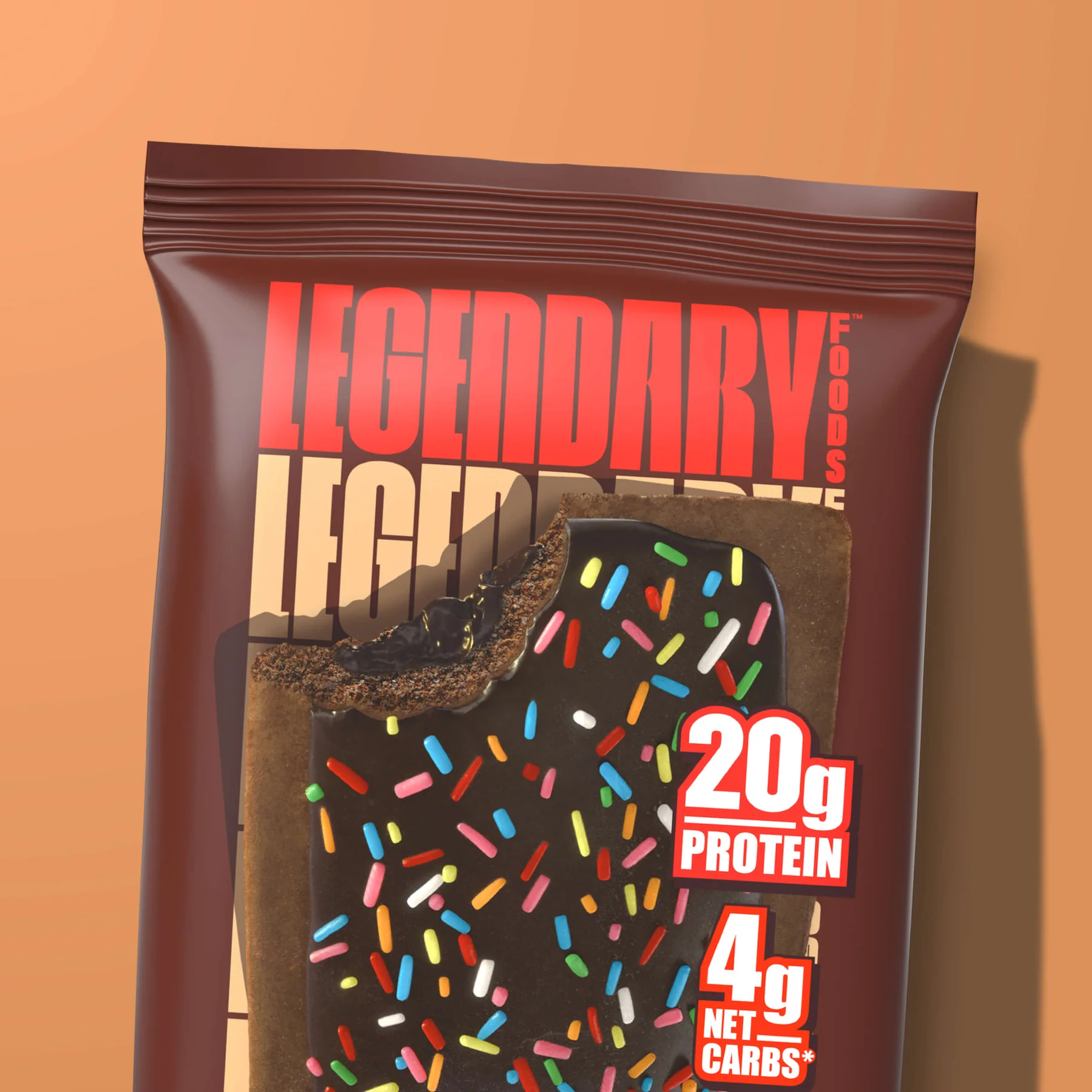 A chocolate protein bar with colorful sprinkles, labeled Legendary Foods and showing 20g PROTEIN and 4g NET CARBS.