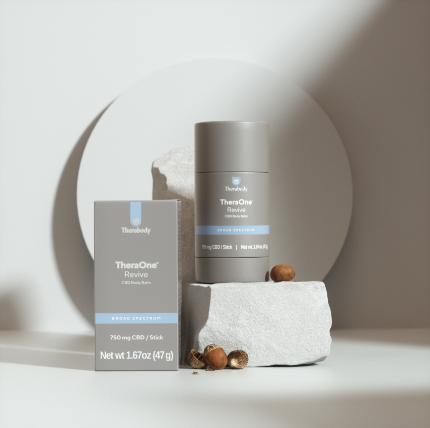 TheraOne Revive CBD Body Balm, 750 mg, 1.67 oz, on a white background with hazelnuts and a circular shadow.