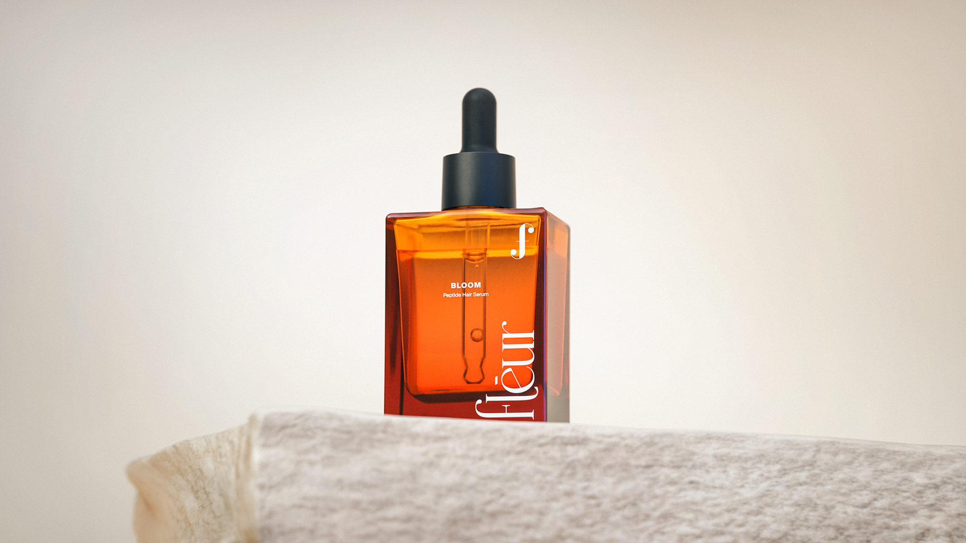 A sleek, amber-colored bottle of "BLOOM" peptides, featuring a minimalist design with a black cap and a clear label.