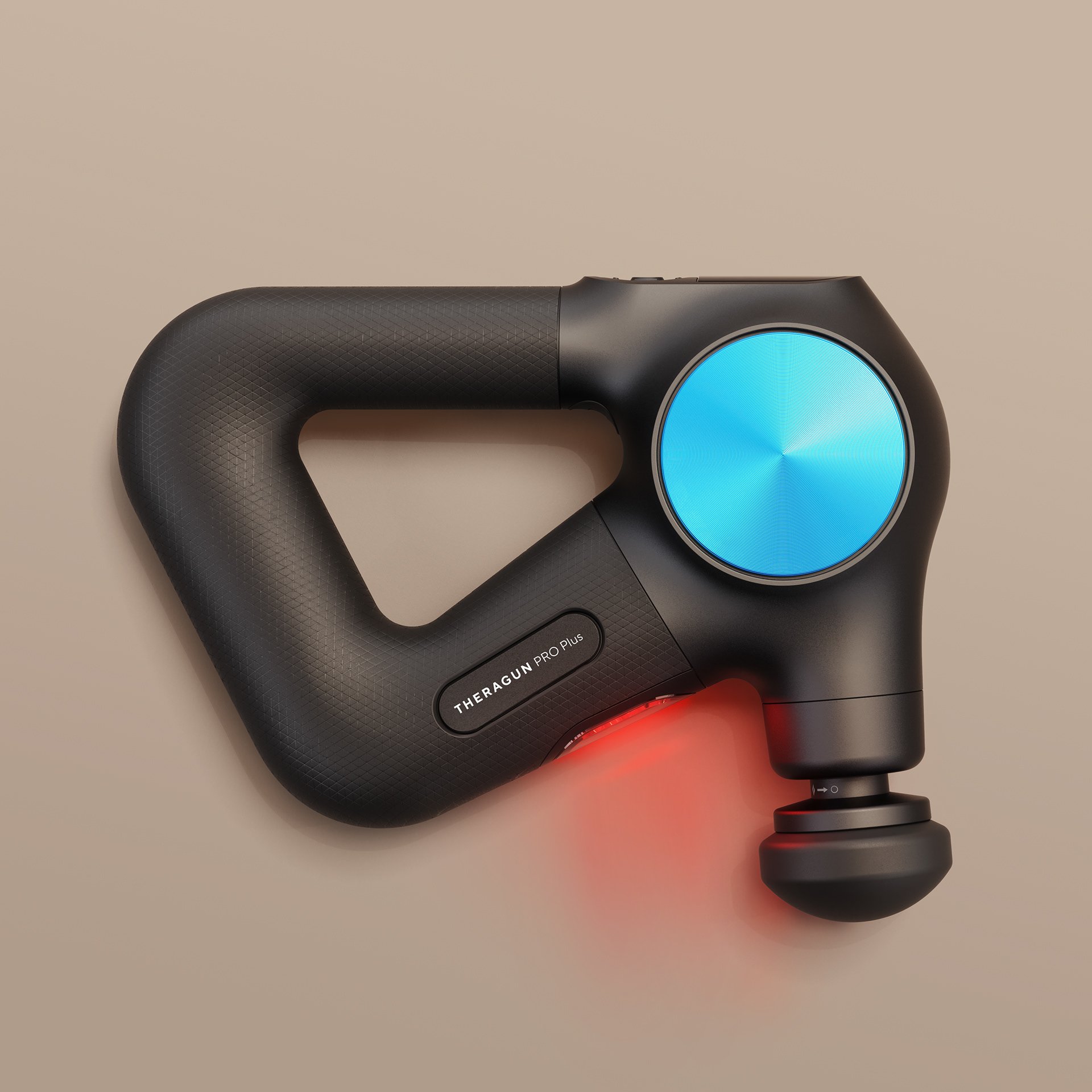 A black Theragun Pro Plus massage gun with a blue circular massager head and red light on, against a neutral background.