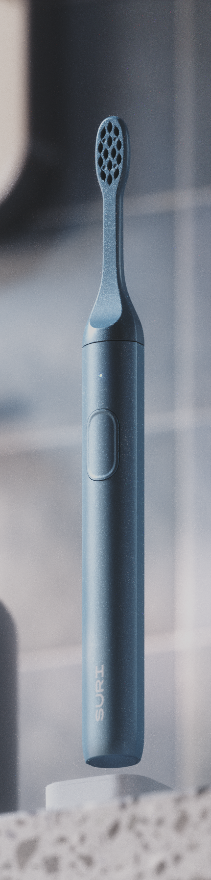 A sleek, dark blue electric toothbrush with a textured head and a button on its side, displayed against a blurred bathroom background.