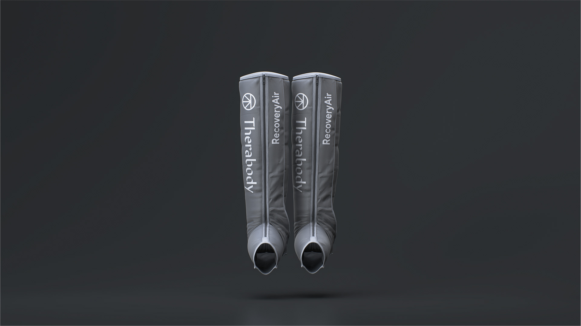 Two gray compression sleeves labeled "Therabody Recovery Air" stand upright against a dark background.