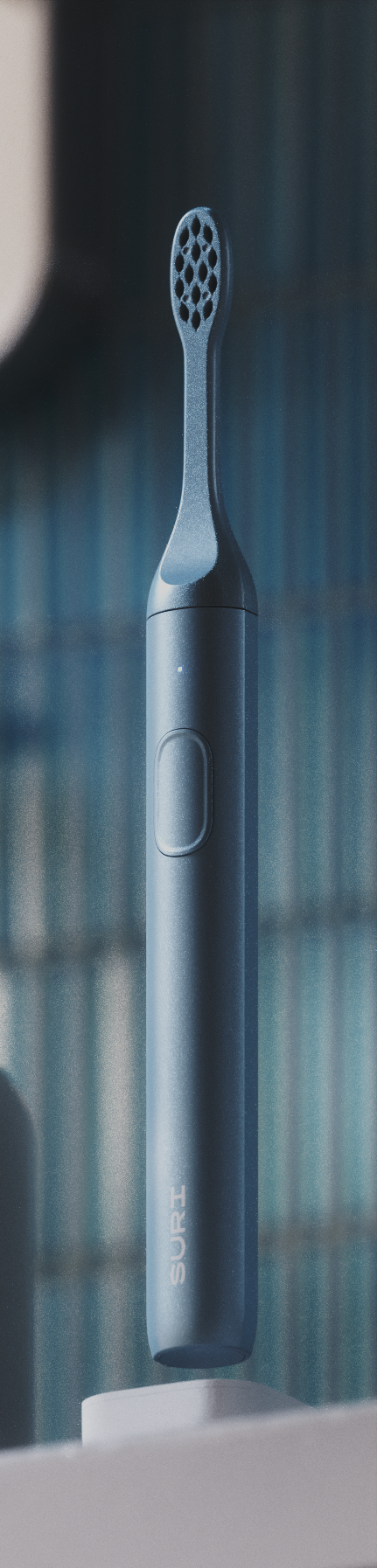 A sleek, dark blue electric toothbrush with "SURI" branding on its side, standing upright against a blurred background.