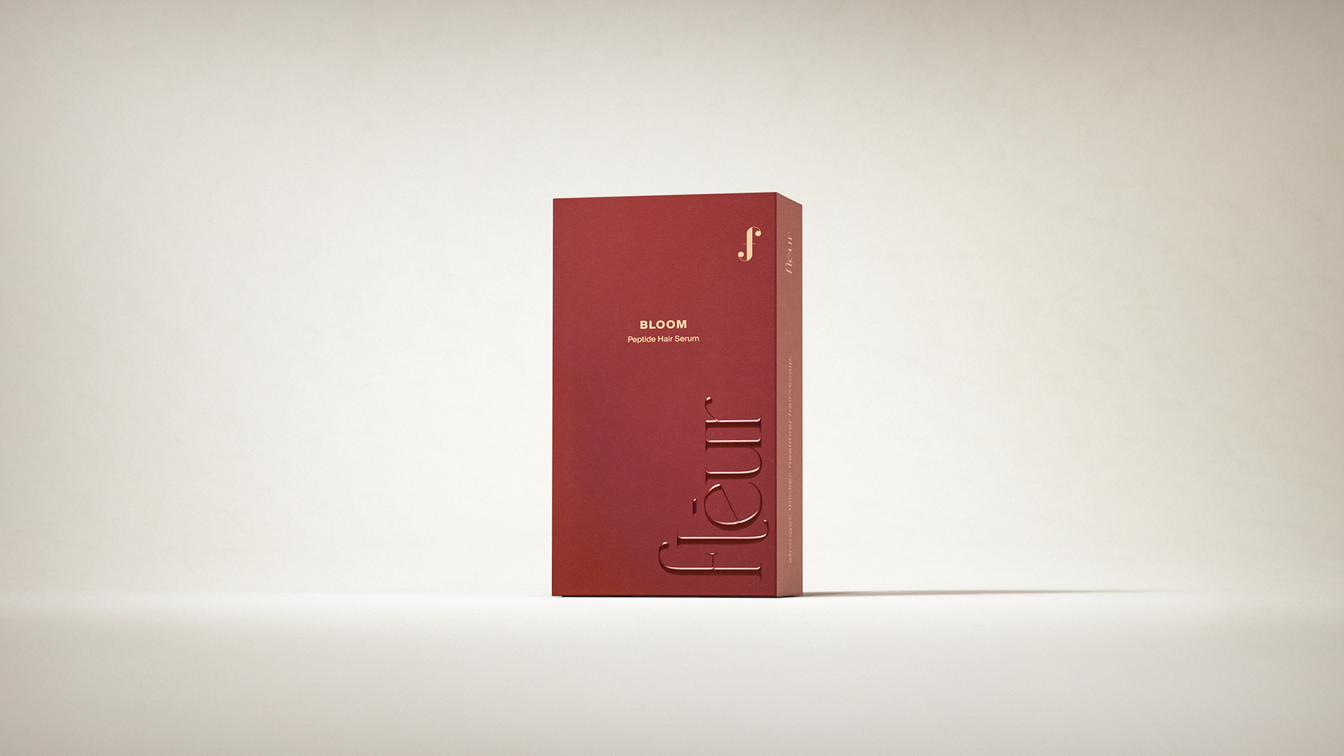 A red rectangular box with embossed text "fleur" and "BLOOM" on a plain background.