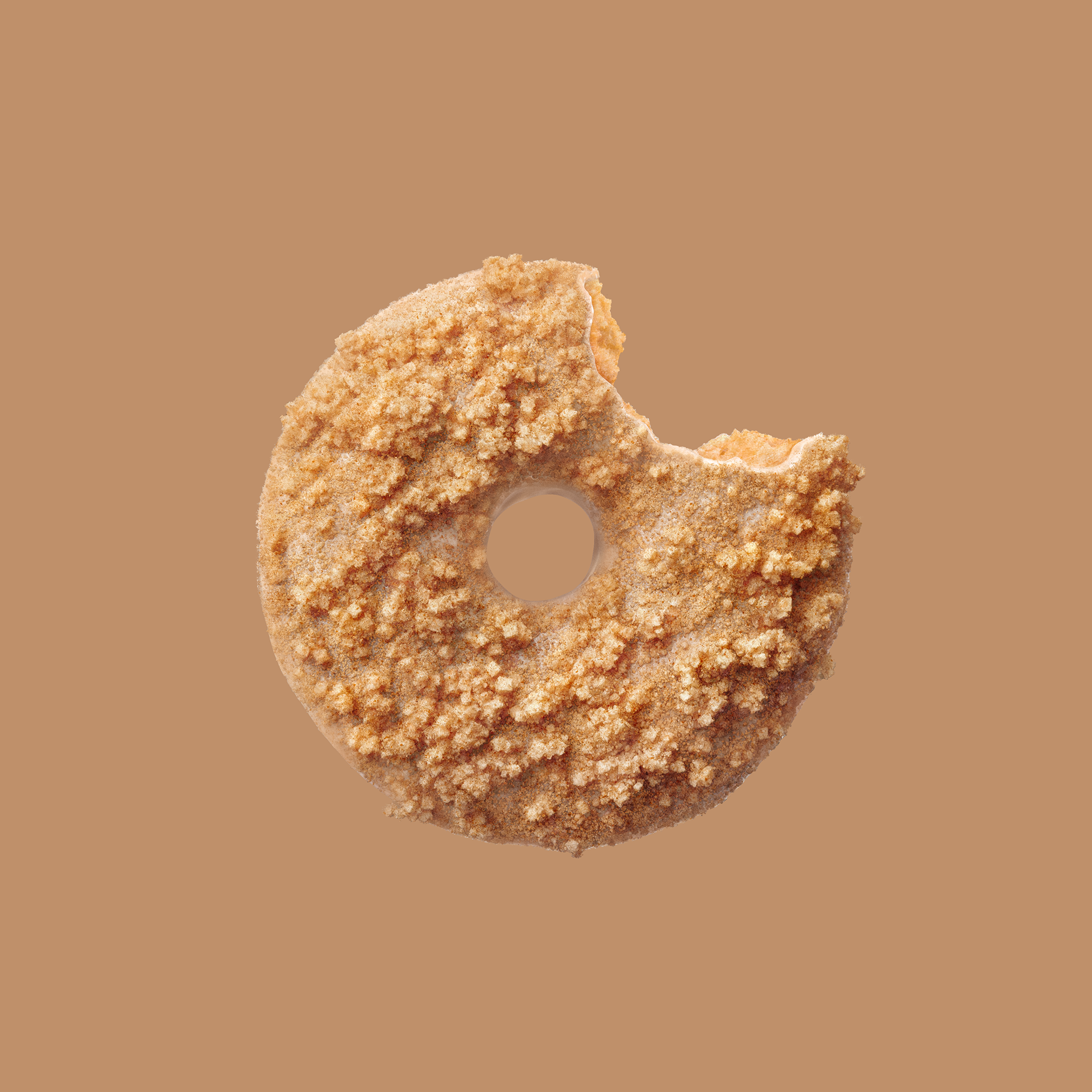 A single, partially eaten biscuit with a light brown, crumbly texture against a solid beige background.