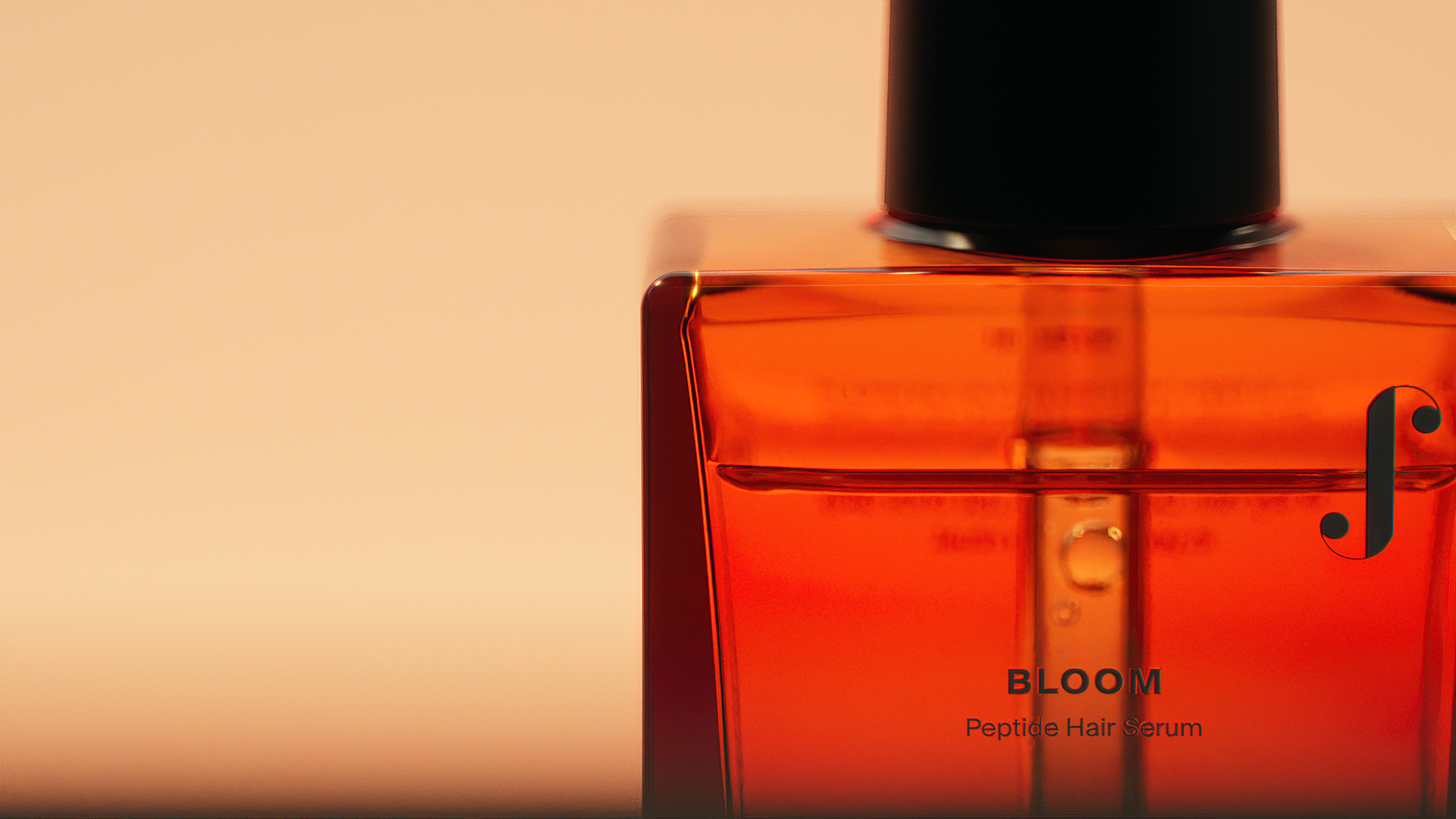 A close-up of an amber-colored bottle labeled "BLOOM Peptides Hair Serum" against a soft pink background.