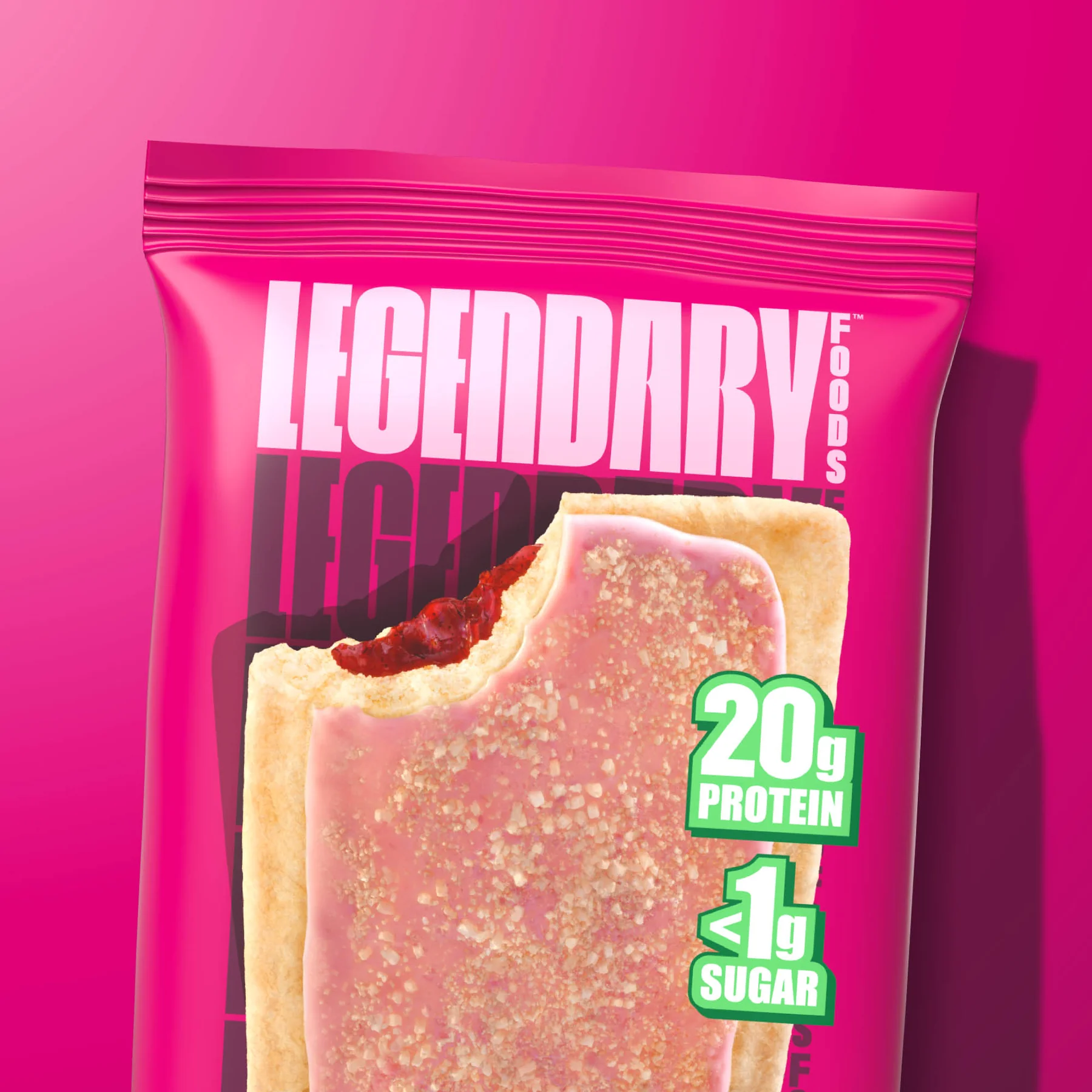 A pink snack bar package with a white filling, showing "20g PROTEIN" and "<1g SUGAR" on a green label, against a vibrant pink background.