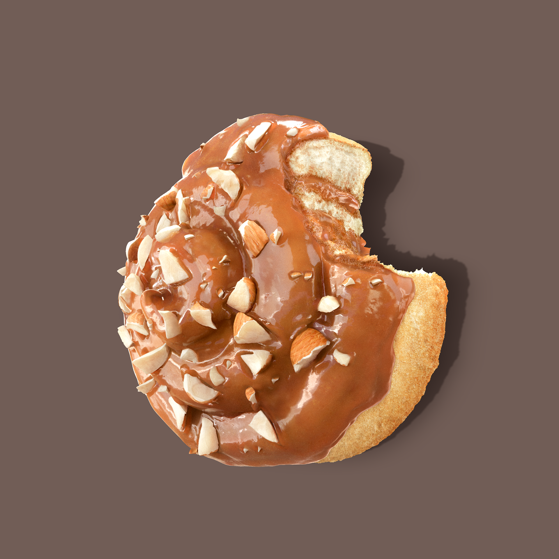 A chocolate-covered doughnut with nuts on top, partially eaten, against a dark background.