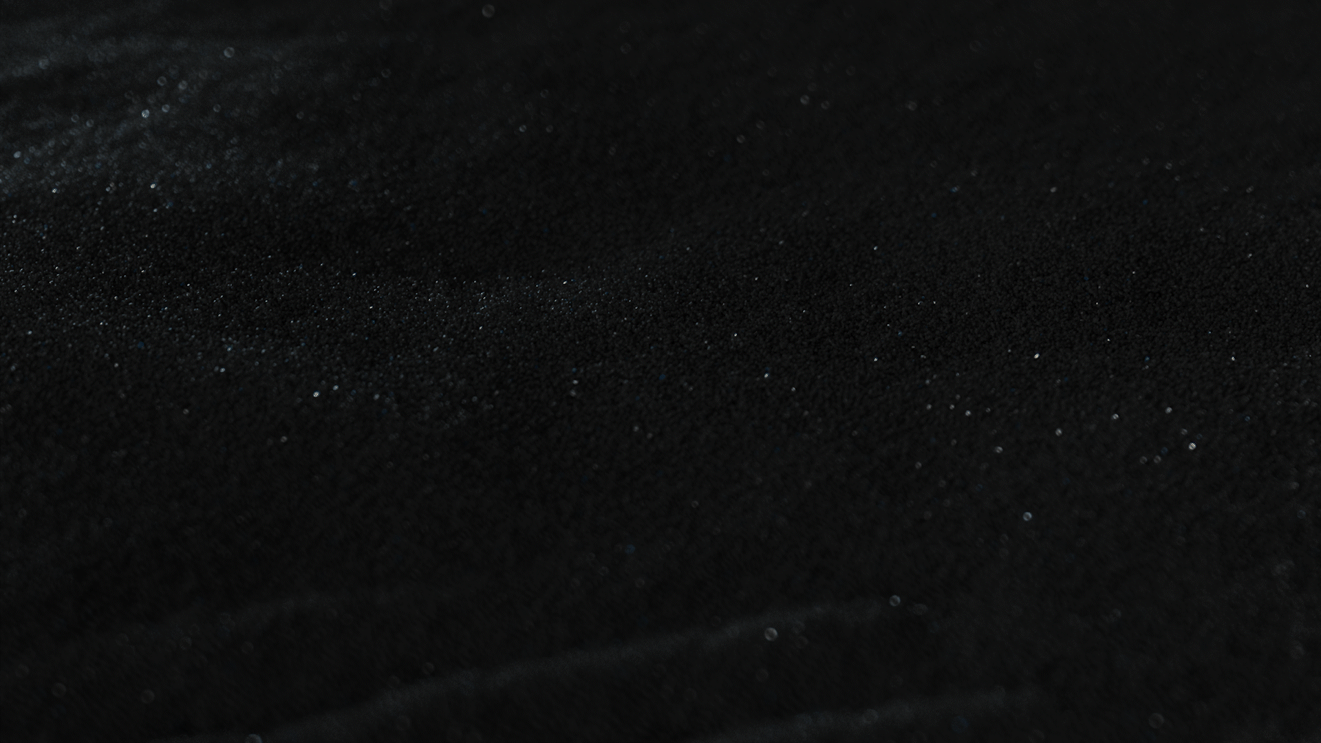 Animated sequence: A close-up of a black surface with golden particles swirling and forming circular patterns.