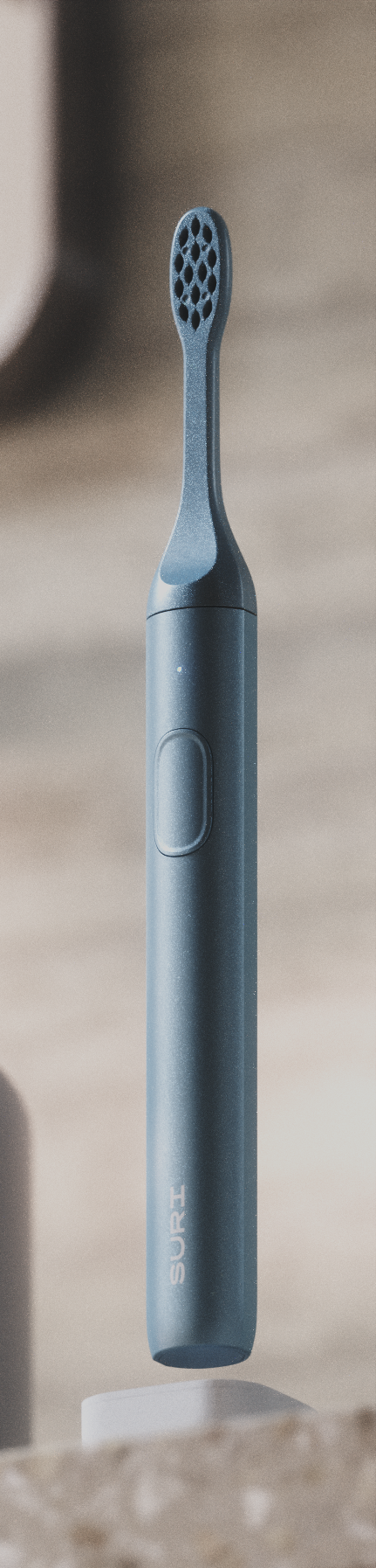 A sleek, dark blue electric toothbrush with a textured head and a button on the side, labeled SURI.