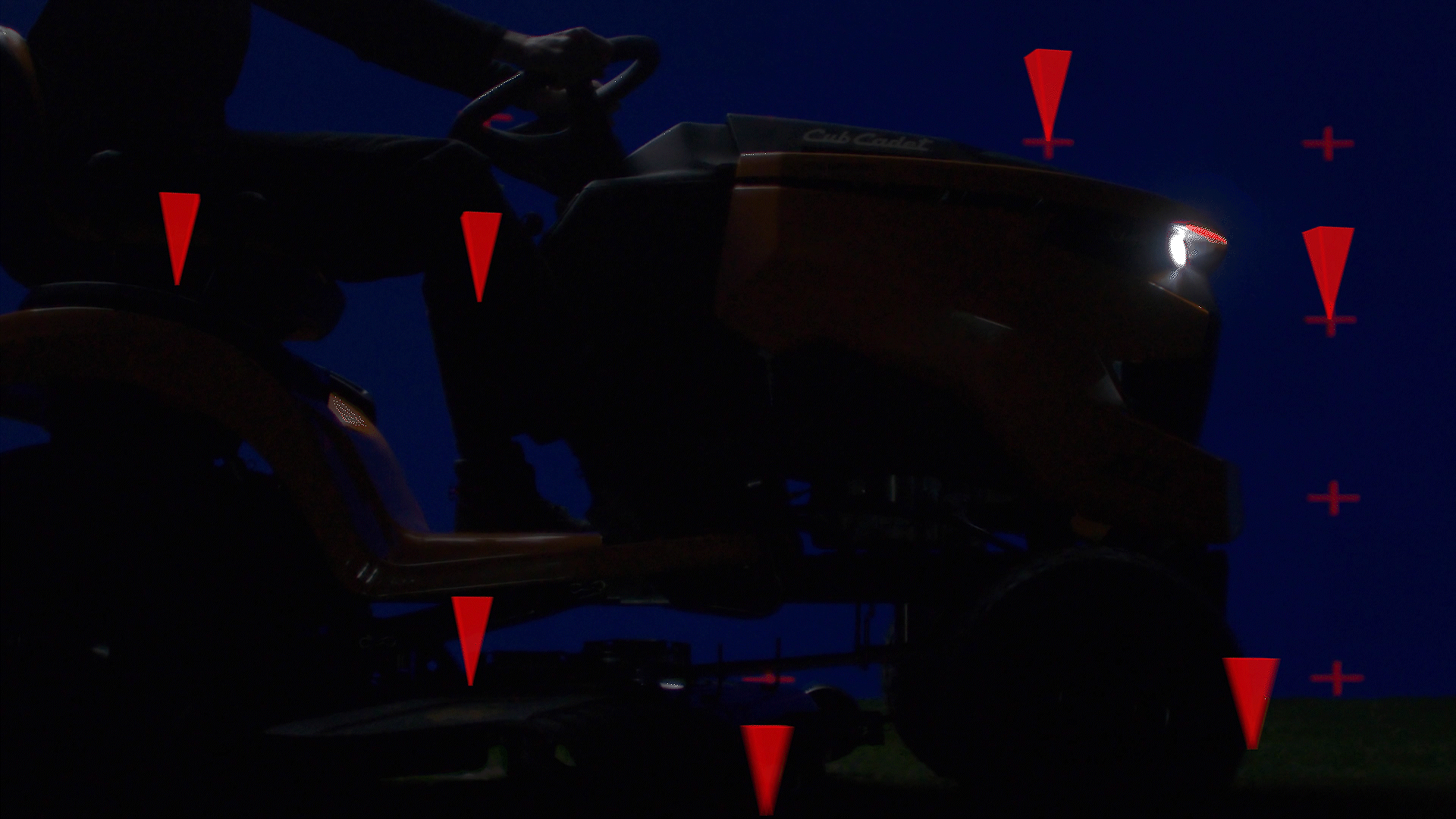 Animated sequence: A lawn mower with a red and black color scheme, featuring a large blade and a handle, set against a dark background with red triangular shapes.