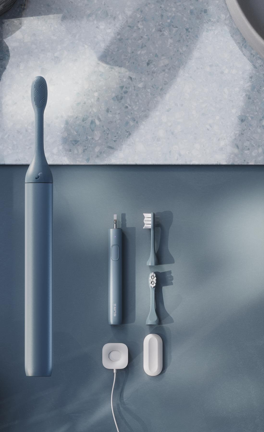 A sleek, minimalist packaging still life featuring a blue toothbrush, charger, and accessories on a textured surface.