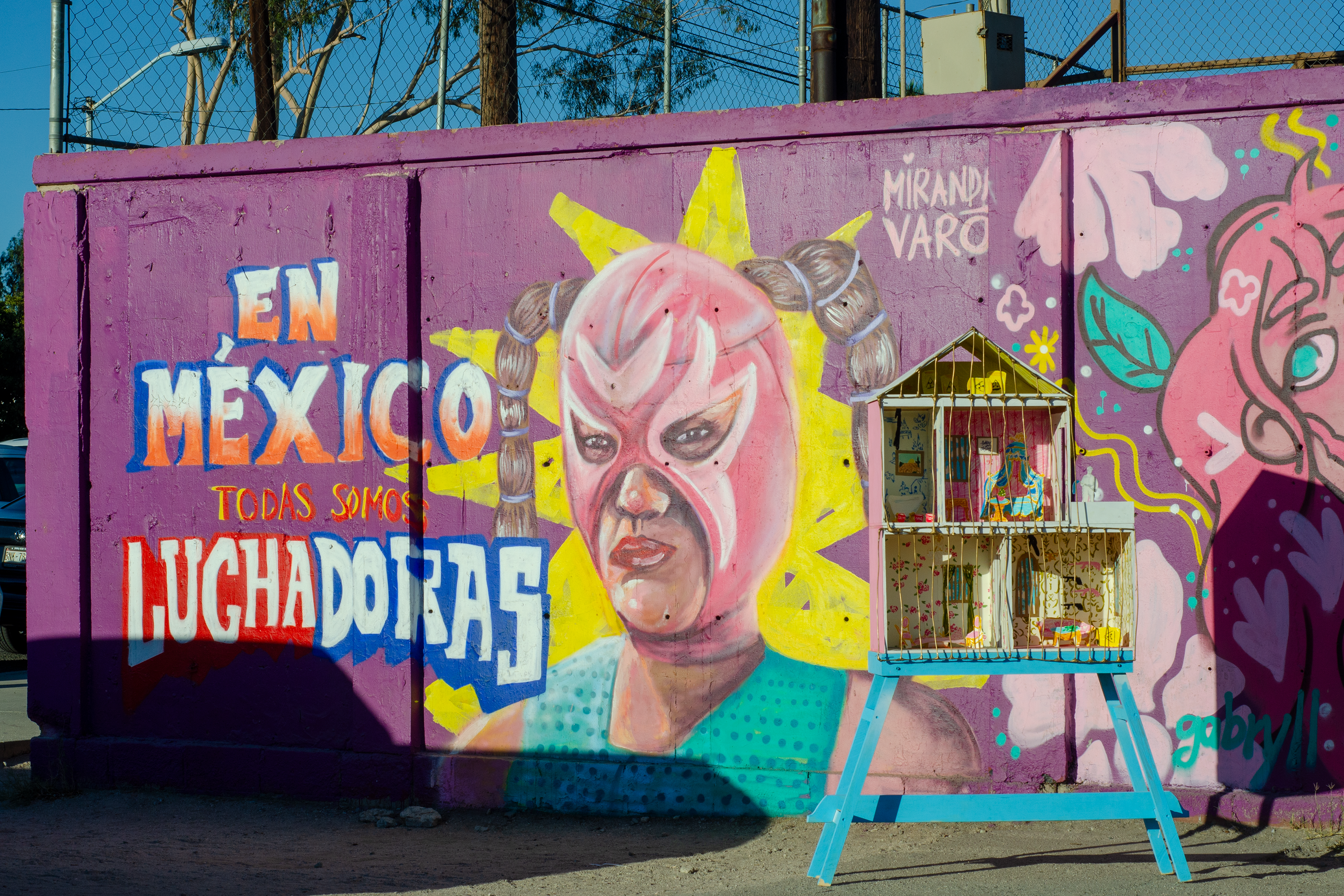 Registro de "Trampa Reluciente" de Miranda Varo junto a un mural de la artista