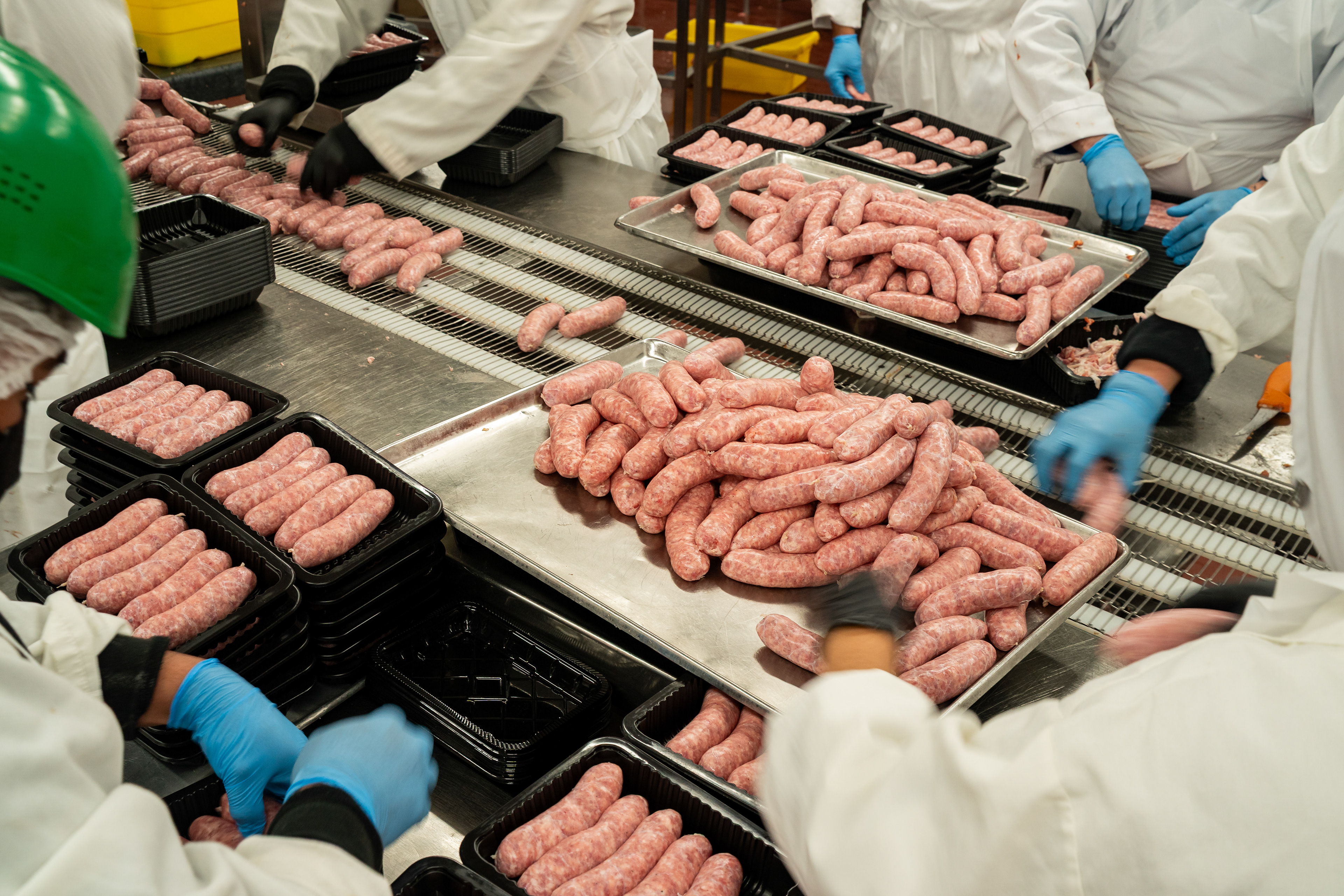 Workers put sausages into trays at New York Style Sausage Company's manufacturing facility in Sunnyvale, California on October 23, 2025. Mountain View Voice