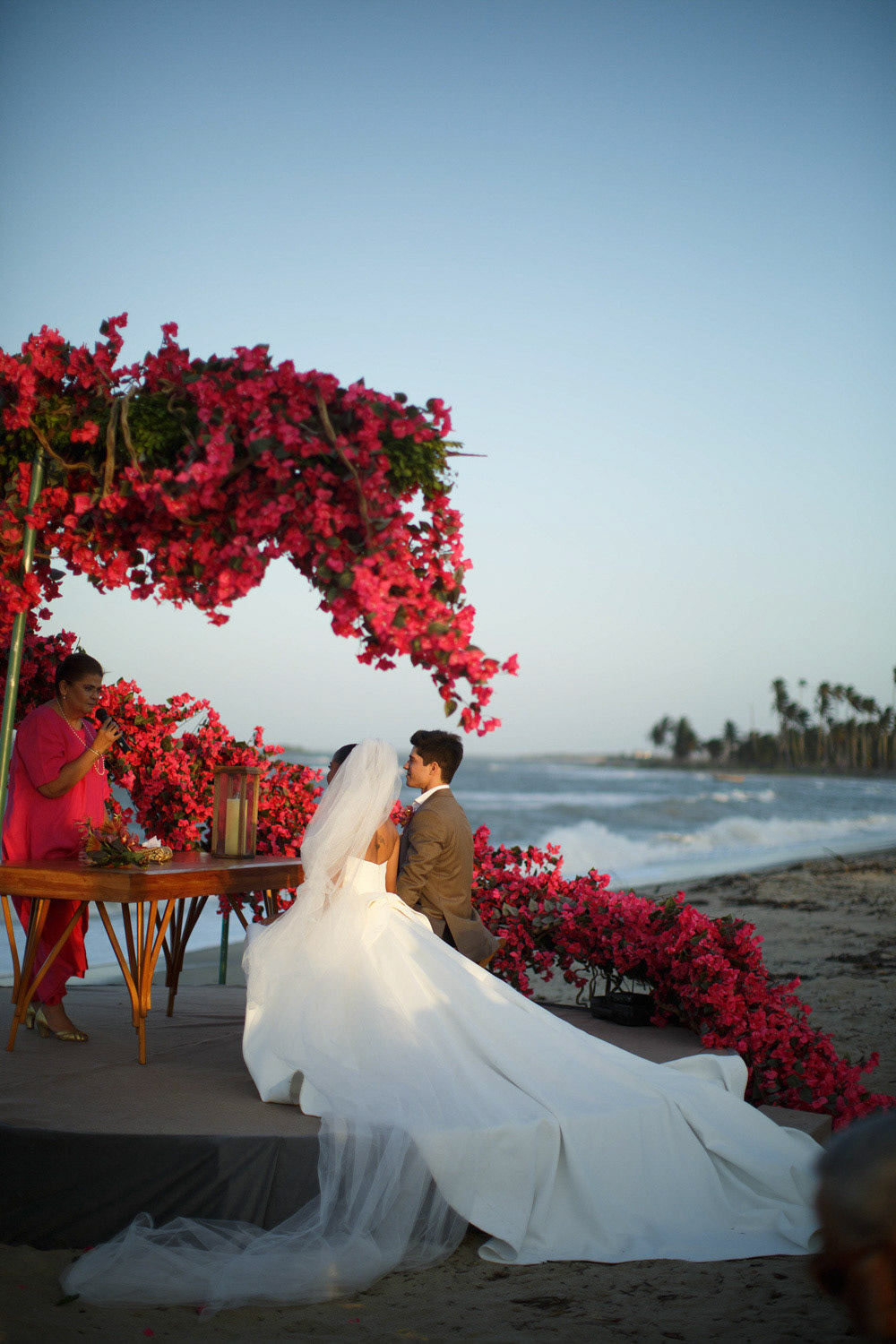 Cerimônia de casamento pé na areia com altar decorado com arco de bougainvilleas pink e vista para o mar. Clique de Rebeca Santos na praia de Barra Grande, litoral do Piauí.