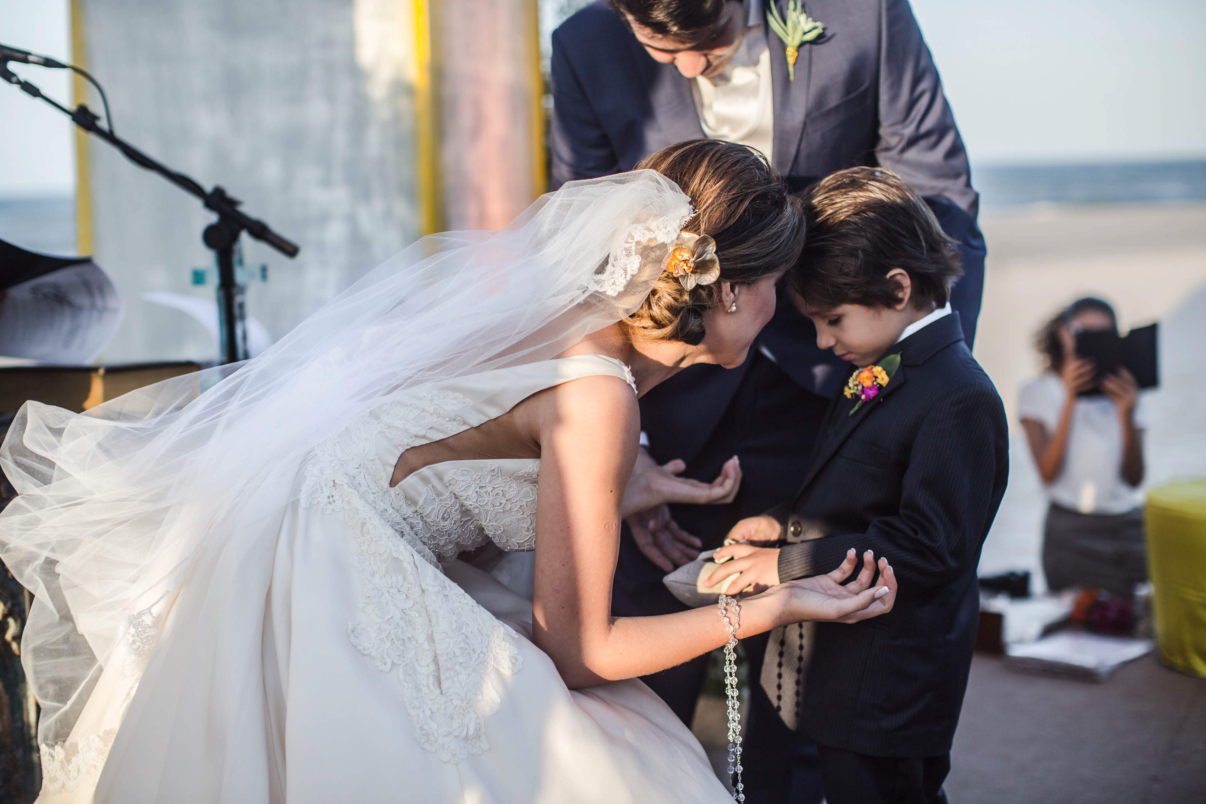 Noiva recebe as alianças de uma criança no resort Carmel Charme em Aquiraz-CE