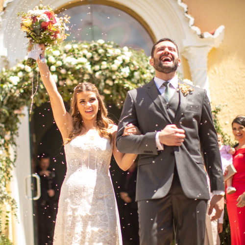 Casal recebe chuva de arroz dos convidados na saída da capela do Colégio Dom Barreto capela durante o dia em Teresina