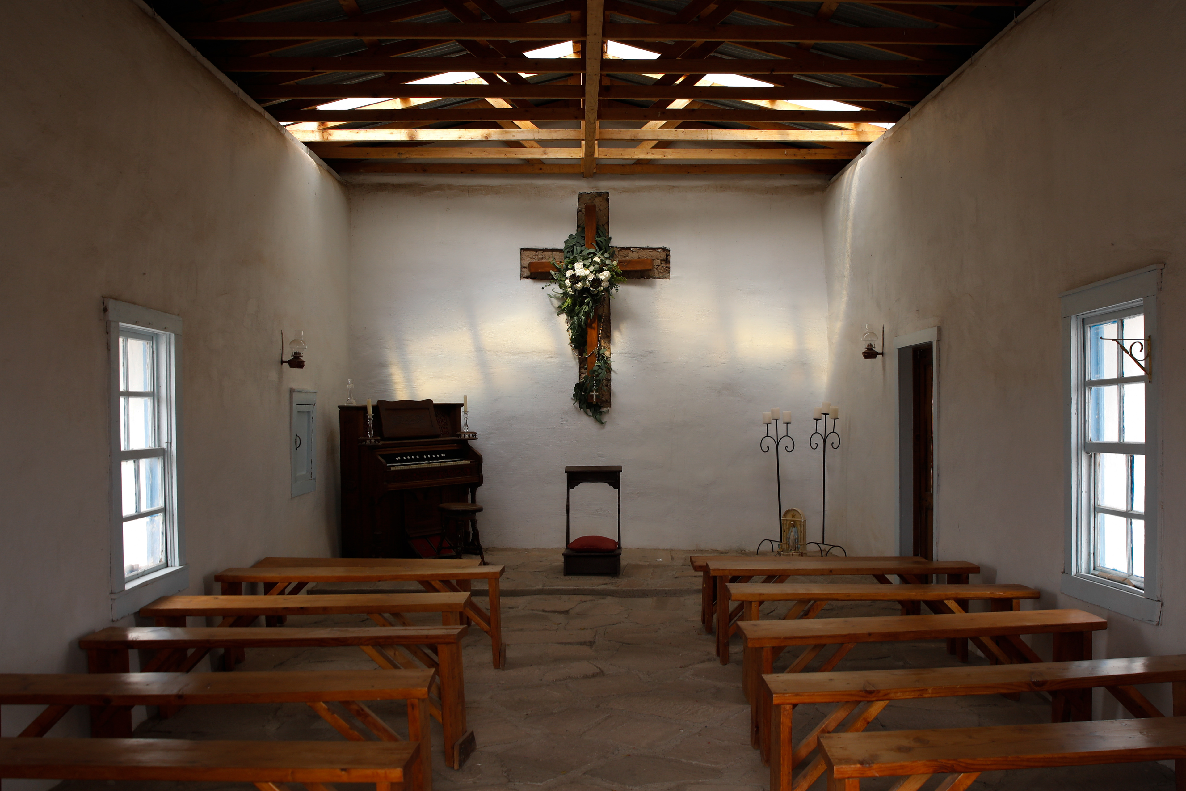 The inside of Calera Chapel,  originally called Mission Mary, the only remaining building in the now empty town of Calera, roughly three miles West of Balmorhea, Texas, March 12, 2024. According to Betty Armstrong of Balmorhea, Texas, and Mark Dent, journalist for Texas Monthly, Calera Chapel was originally built by the Mexican-American settlers in the community of about one hundred people in the early 1900s. By the 1940s, after Calera's residents abandoned the town in search of work, the chapel sat empty and abandoned. But in 2002 the Calera Foundation, a non-profit organization with a mission to restore the historic structure, began renovations on the abandoned chapel, culminating in a dedication in May of 2003. Today, the one-room chapel has reopened to the public.